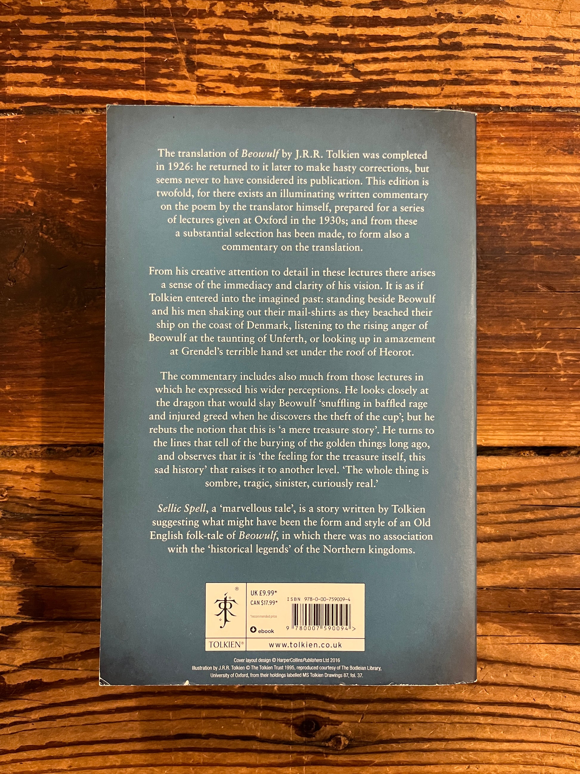 Back cover of book titled 'Beowulf' by J.R.R. Tolkien on a wooden surface
