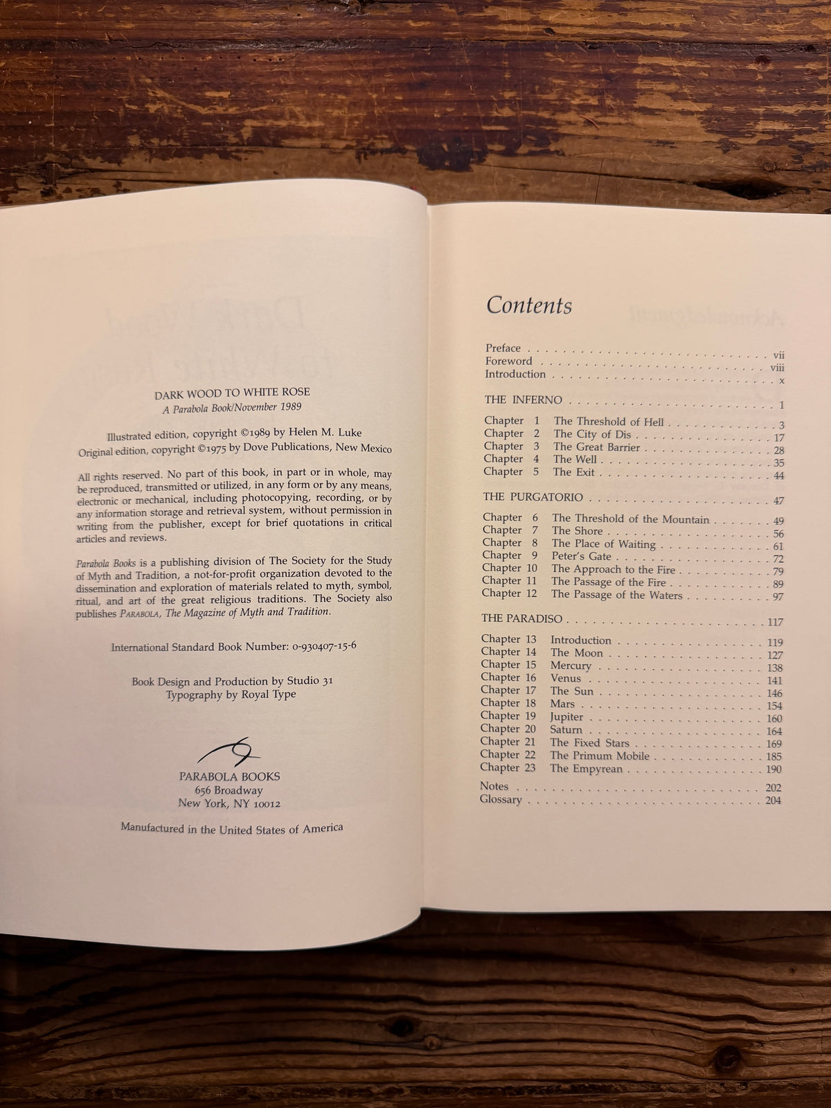 Open book with the title 'Dark Wood to White Rose, journey and transformation in Dante’s Divine Comedy' by Helen M. Luke on a wooden surface 