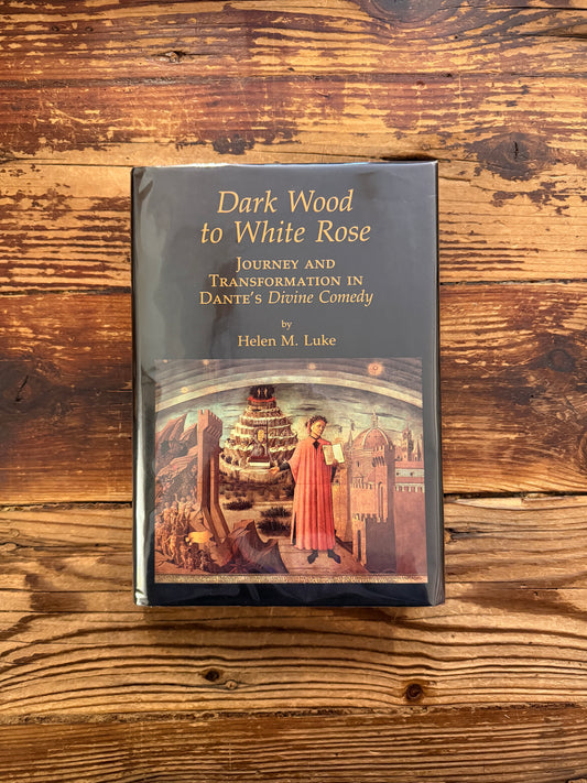Front cover of a book with the title 'Dark Wood to White Rose, journey and transformation in Dante’s Divine Comedy' by Helen M. Luke on a wooden surface 