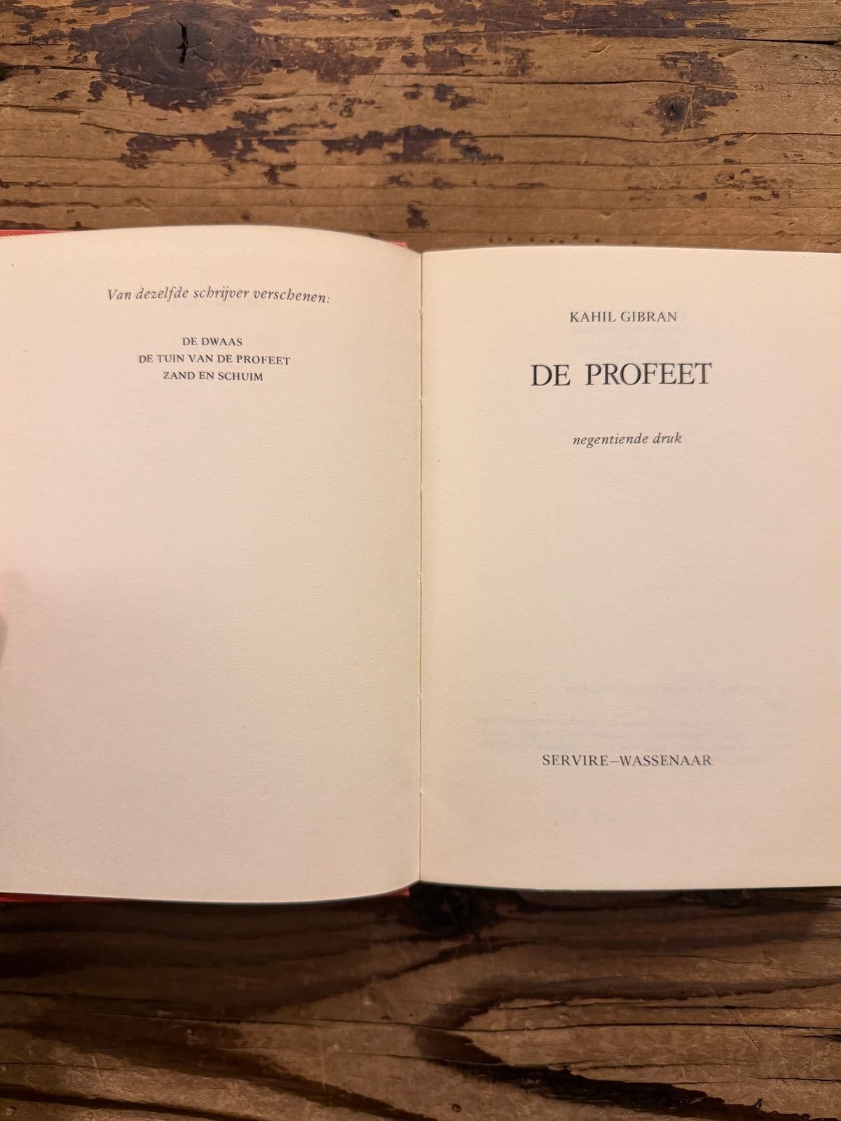 Open boek met de titel 'De profeet' door Kahlil Gibran, op een houten  achtergrond 