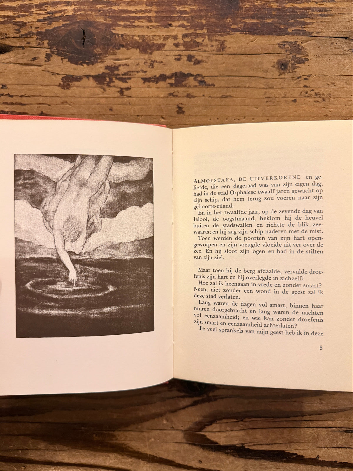 Open boek met de titel 'De profeet' door Kahlil Gibran, op een houten  achtergrond 