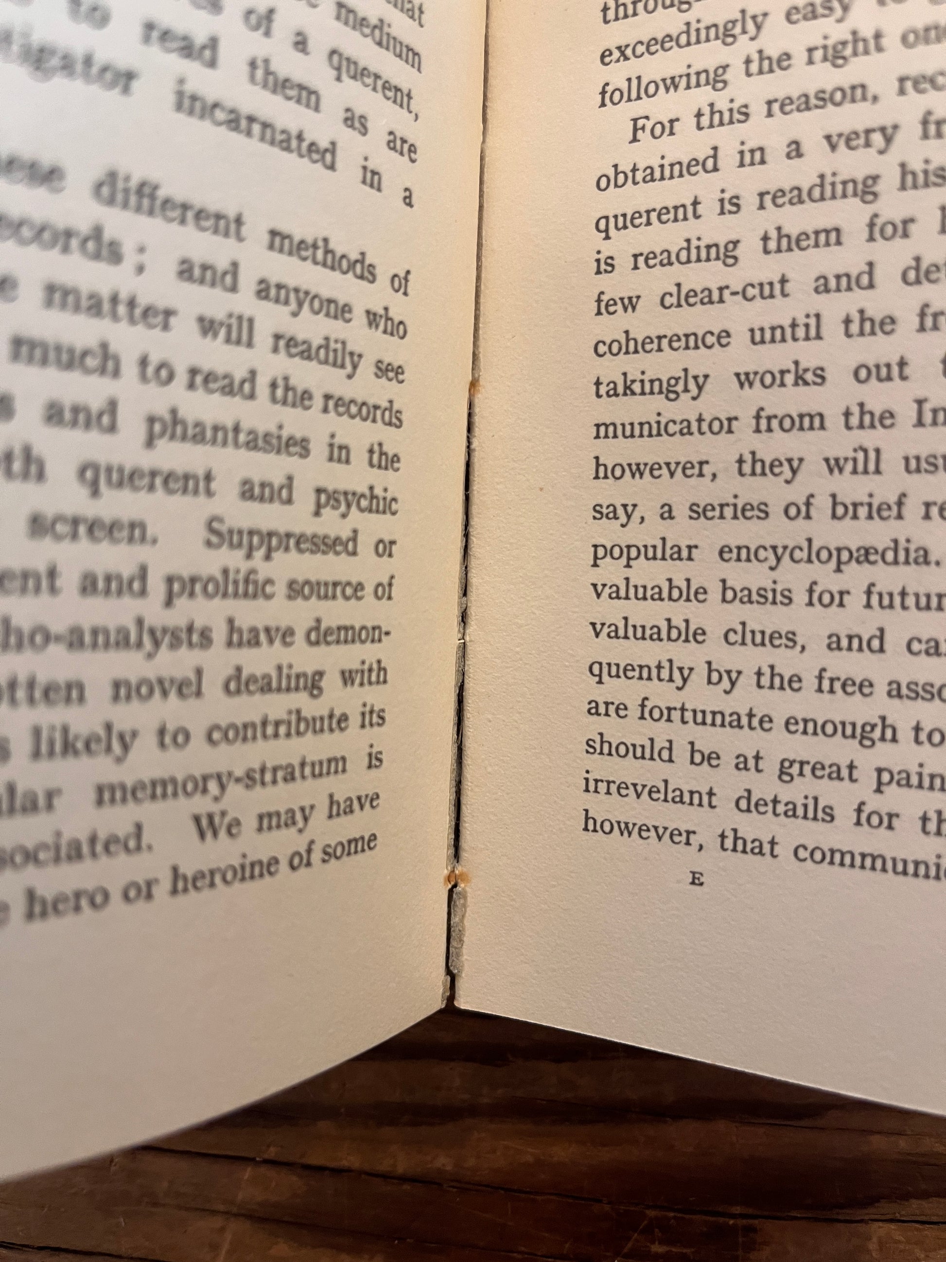 View of the fragile binding of rare first cheap edition of book titled 'sane occultism' by Dion Fortune on a wooden surface 