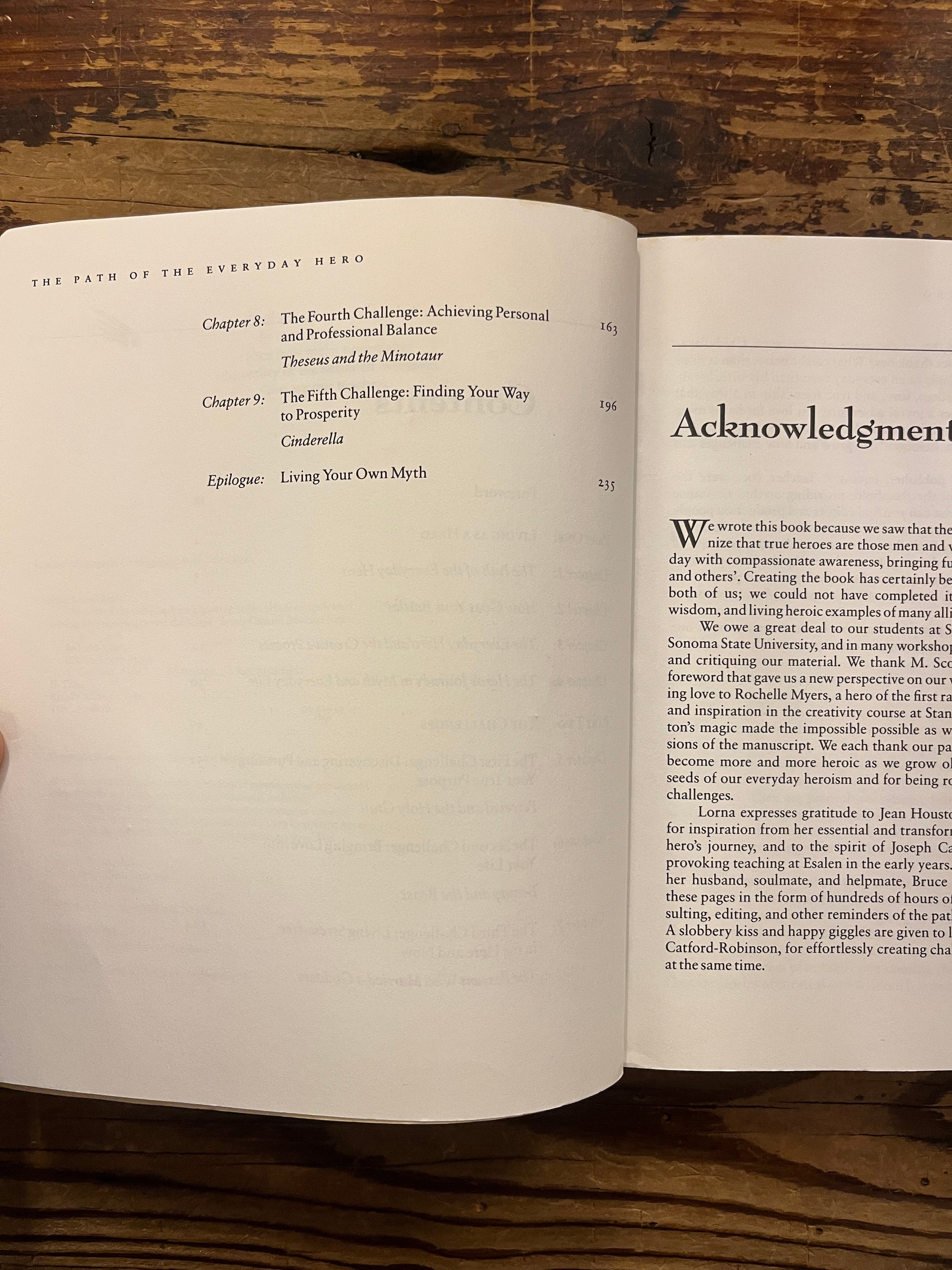 Open book titled 'The Path of the Everyday Hero' on a wooden surface