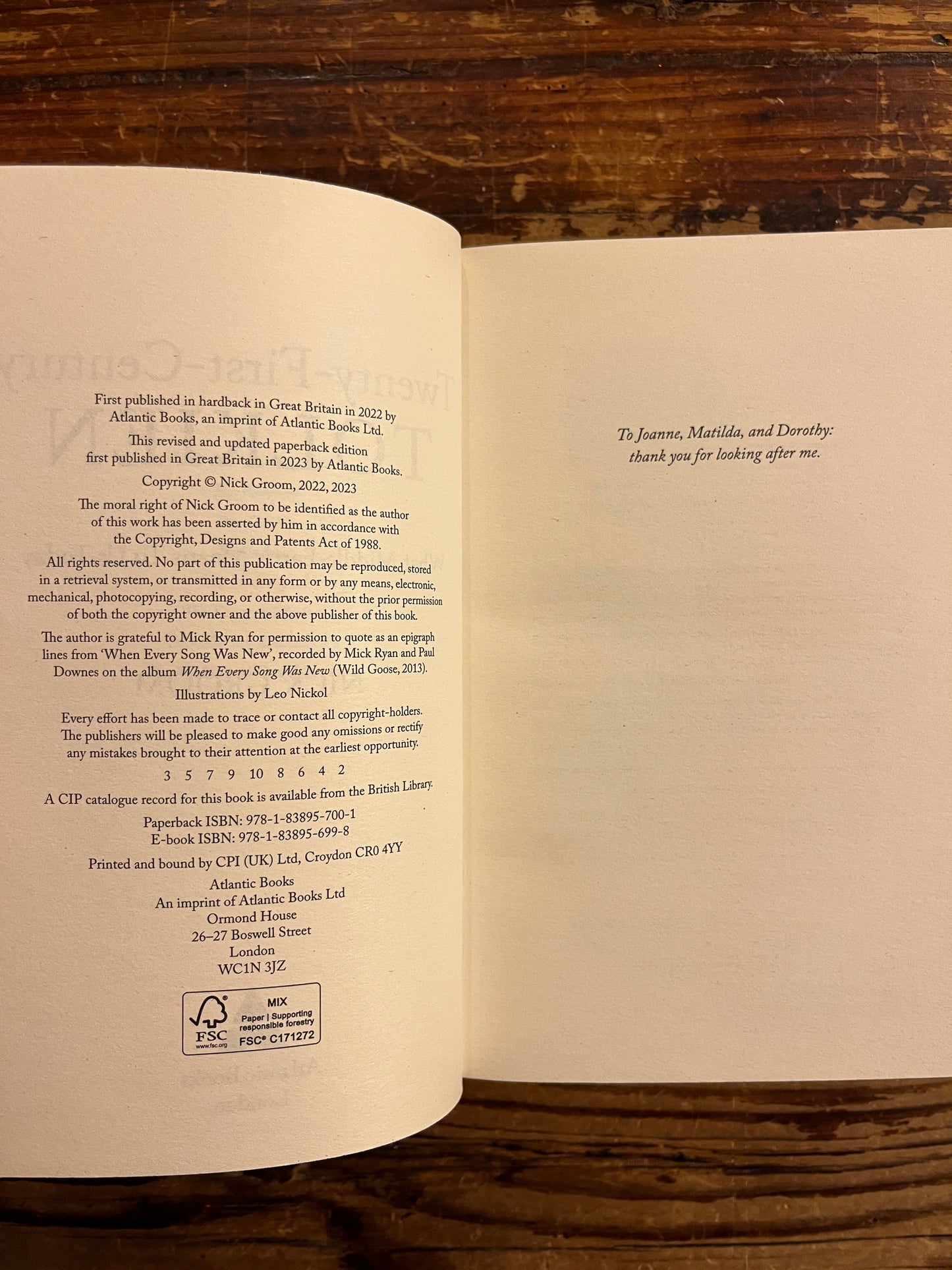 open book titled 'Twenty-First-Century Tolkien' by Nick Groom on a wooden surface