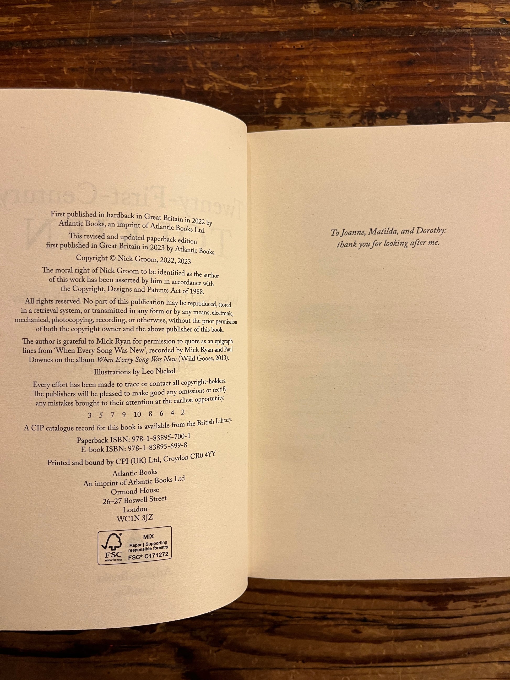 open book titled 'Twenty-First-Century Tolkien' by Nick Groom on a wooden surface