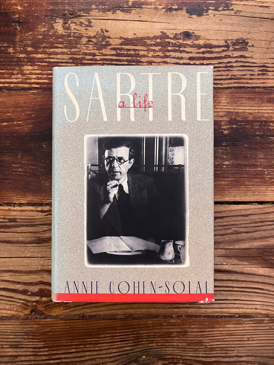 photo of the cover of the book "Sartre"on a wooden background