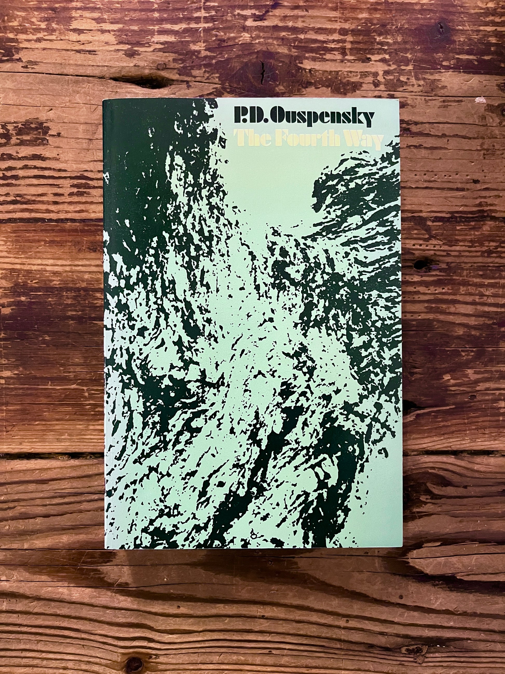 Front cover of a book with the title 'the fourth way' by P.D. Ouspensky on a wooden surface 