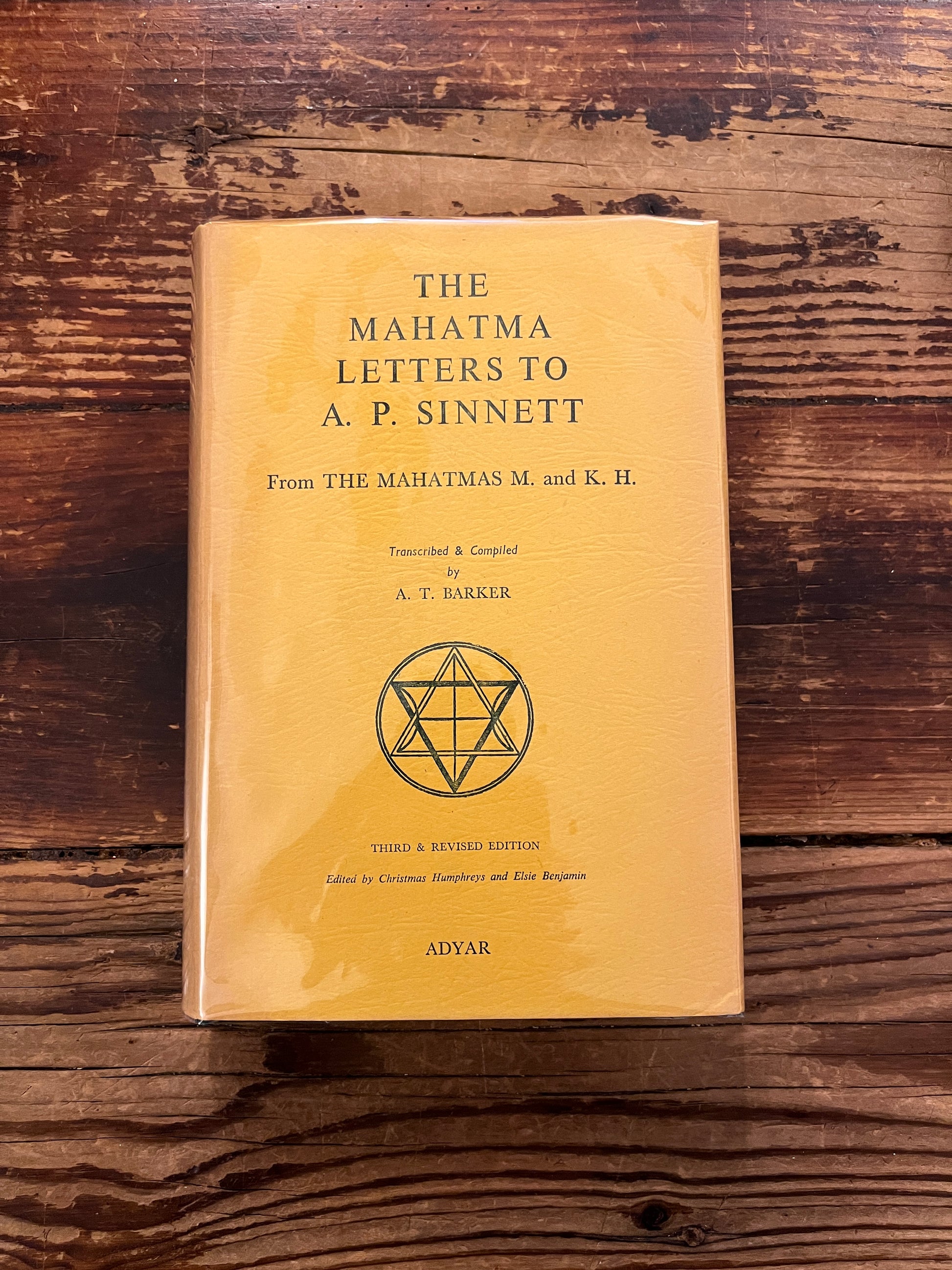 Book titled 'the Mahatma letter to A.P. Sinnett' on a wooden surface 
