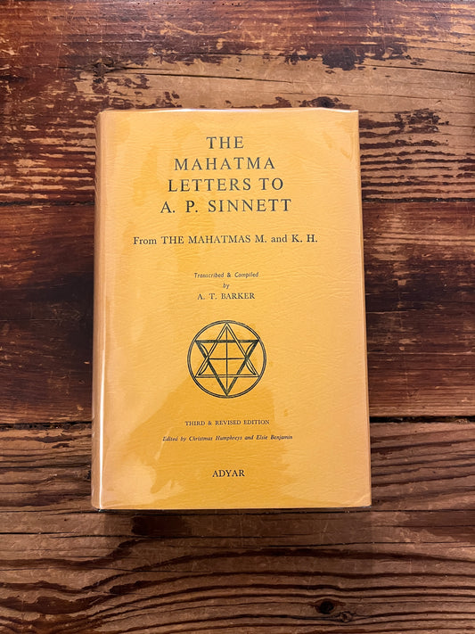 Book titled 'the Mahatma letter to A.P. Sinnett' on a wooden surface 