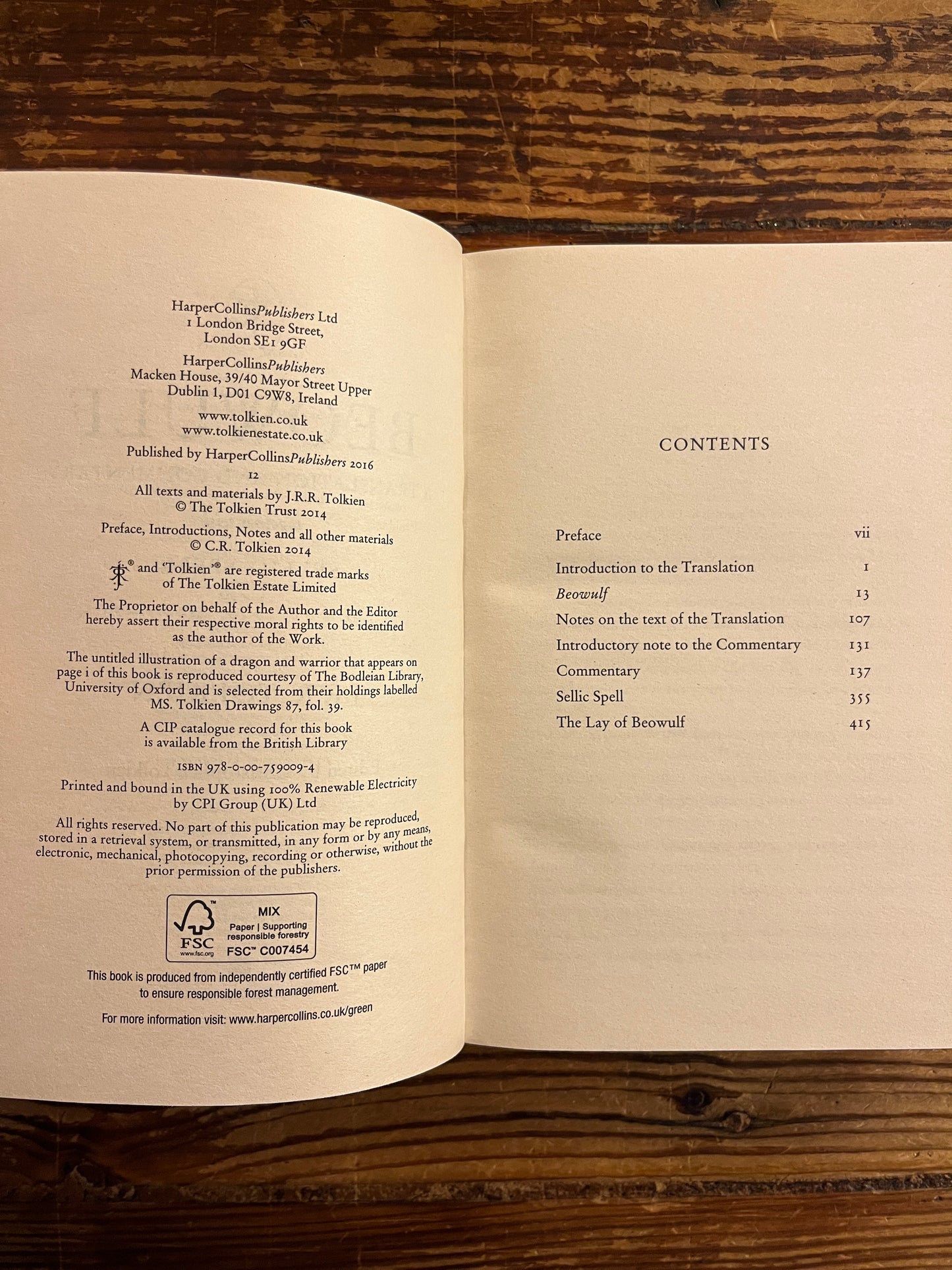 Open Book titled 'Beowulf' by J.R.R. Tolkien on a wooden surface 