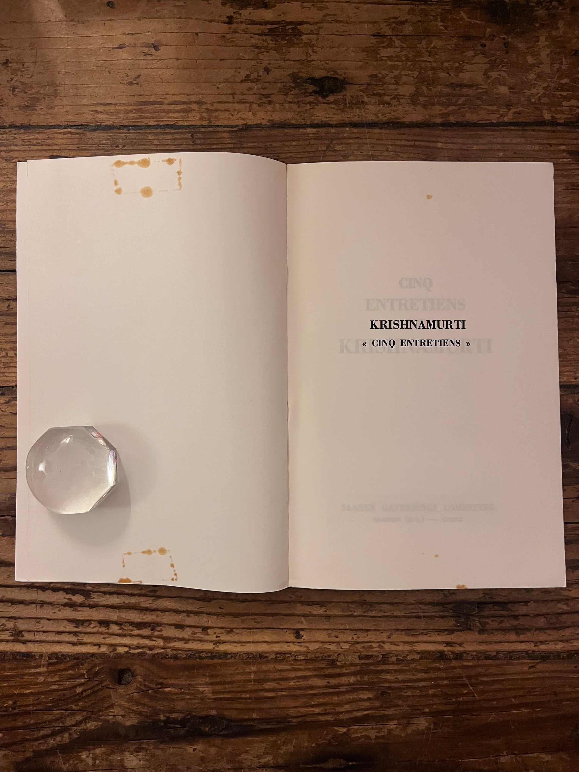 page de tuire du livre" cinq entretiens avec krishnamurti" sur fond de bois