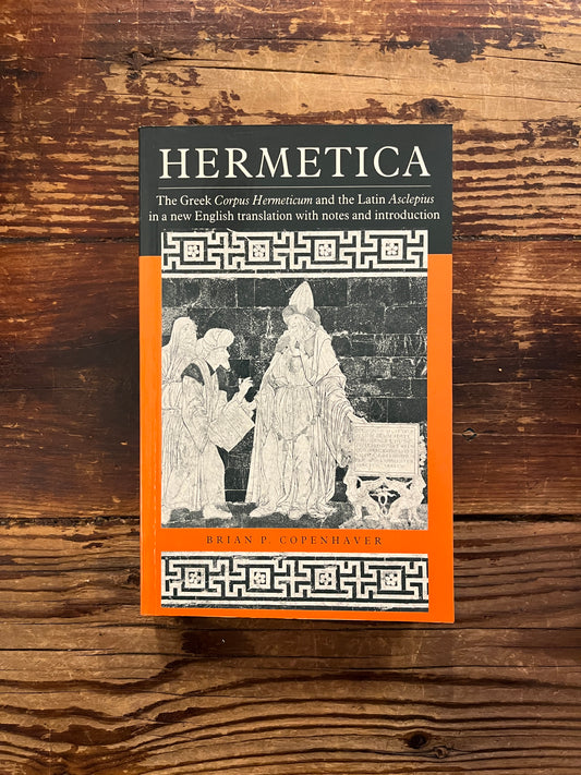 Front cover of book with the title 'Hermetica' door Brian P. Copenhaver on a wooden surface