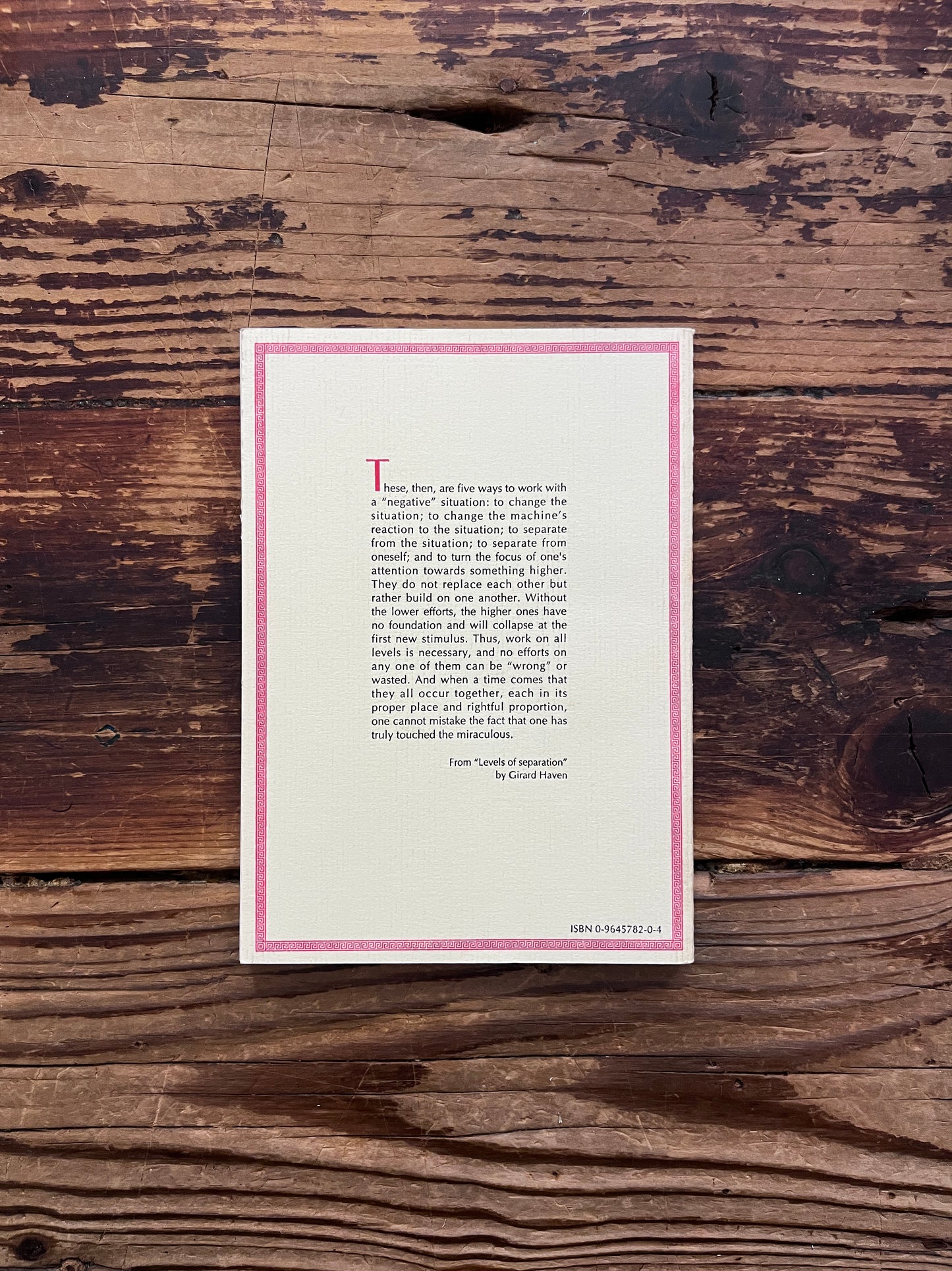 Back cover of a book titled 'thoughts based on the teachings of Robert Burton' by Girard Haven on a wooden surface 