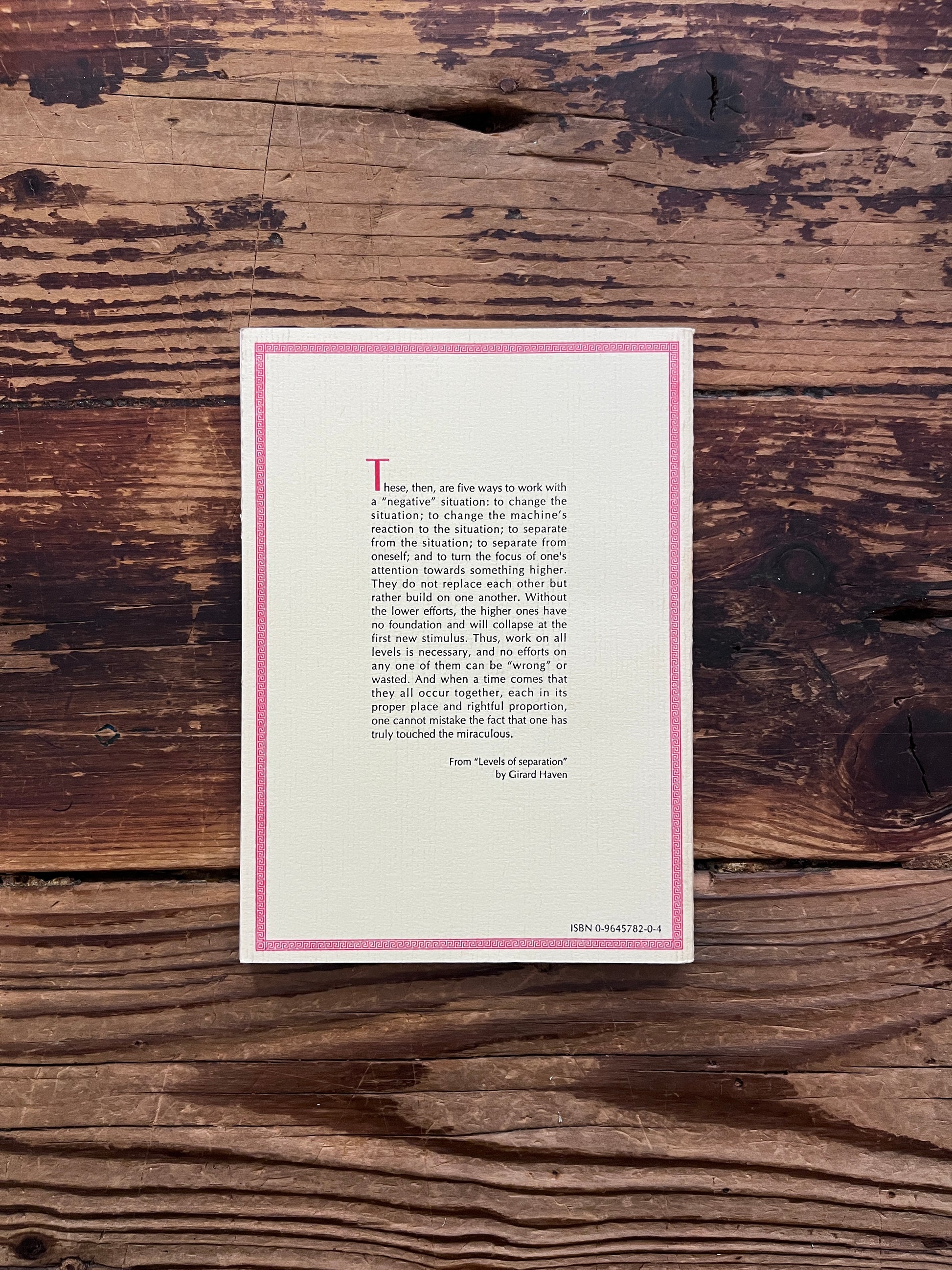 Back cover of a book titled 'thoughts based on the teachings of Robert Burton' by Girard Haven on a wooden surface 