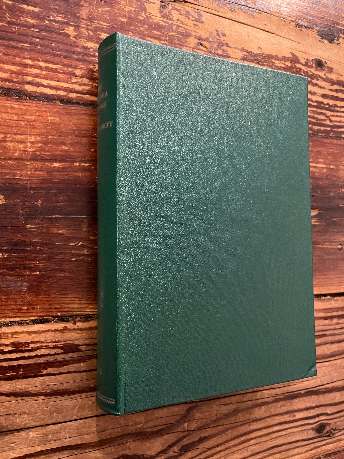 Book without dust jacket titled 'the Mahatma letter to A.P. Sinnett' on a wooden surface 