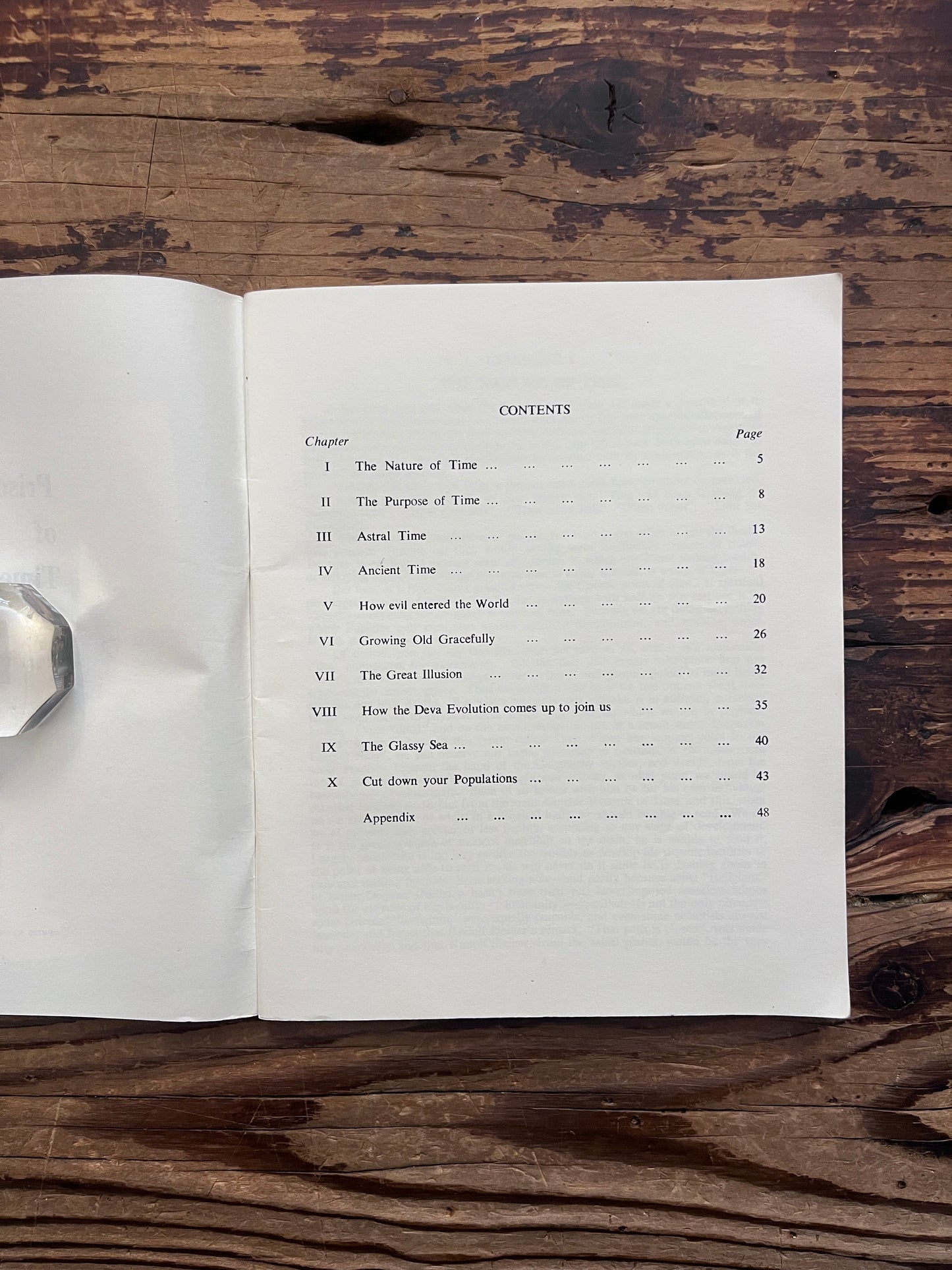 Open booklet showing the contents with the title 'Prisoners of time' by Mollie Moncrieff on a wooden surface 