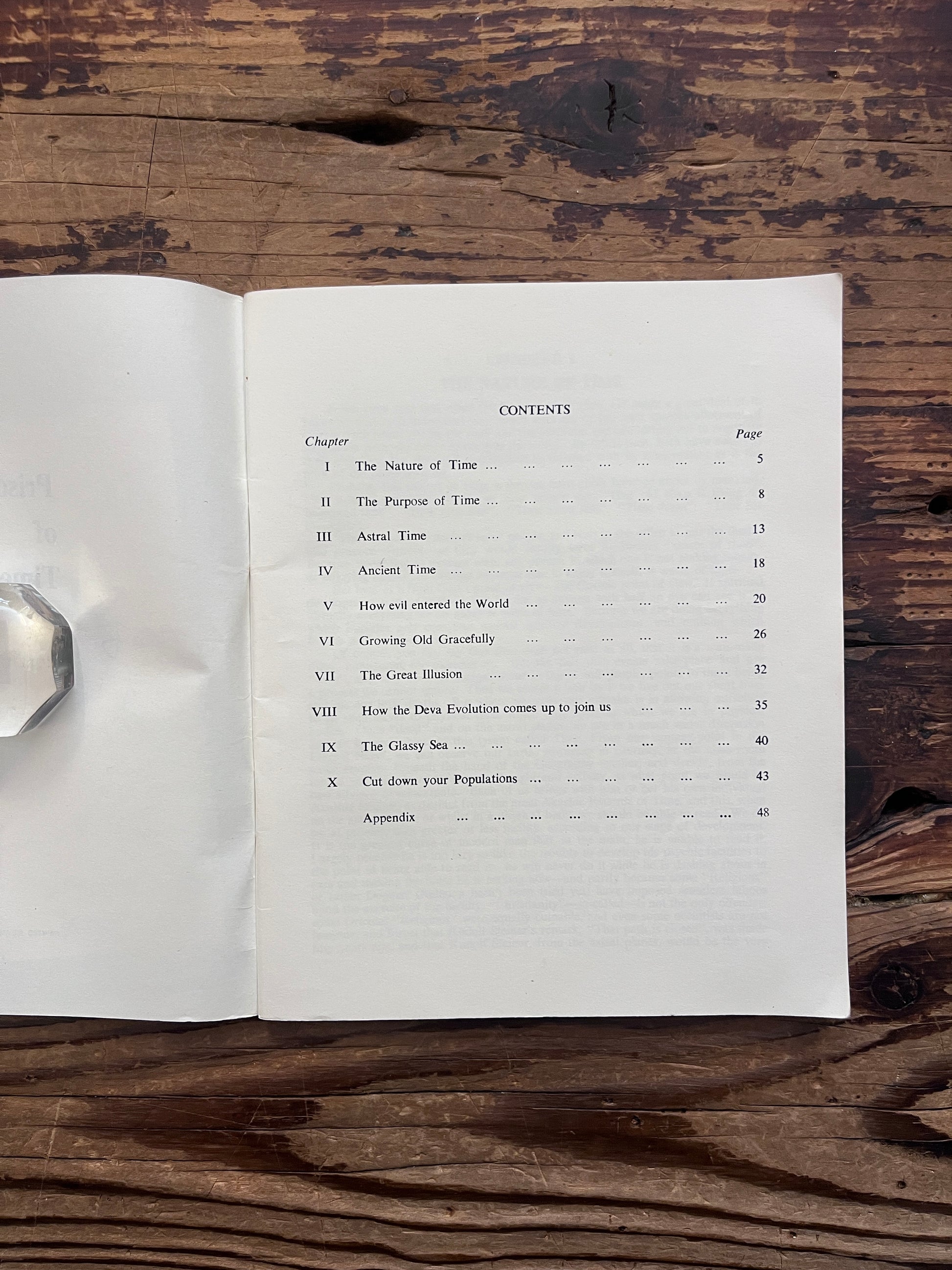 Open booklet showing the contents with the title 'Prisoners of time' by Mollie Moncrieff on a wooden surface 