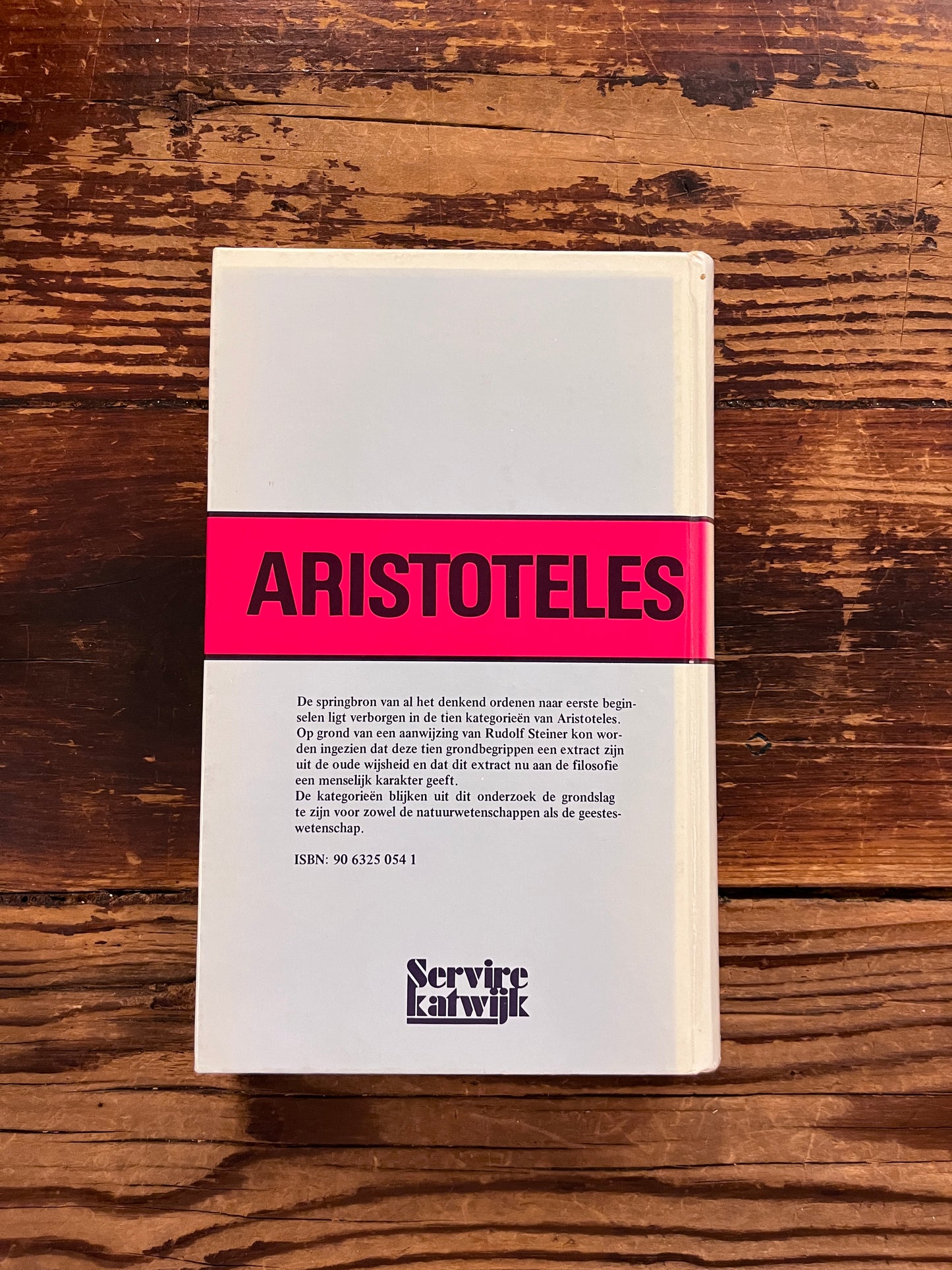 foto van de omslag van het boek " Aristoteles nieuw onderziek naar de betekenis van zijn categorieen" op houten achtergrond