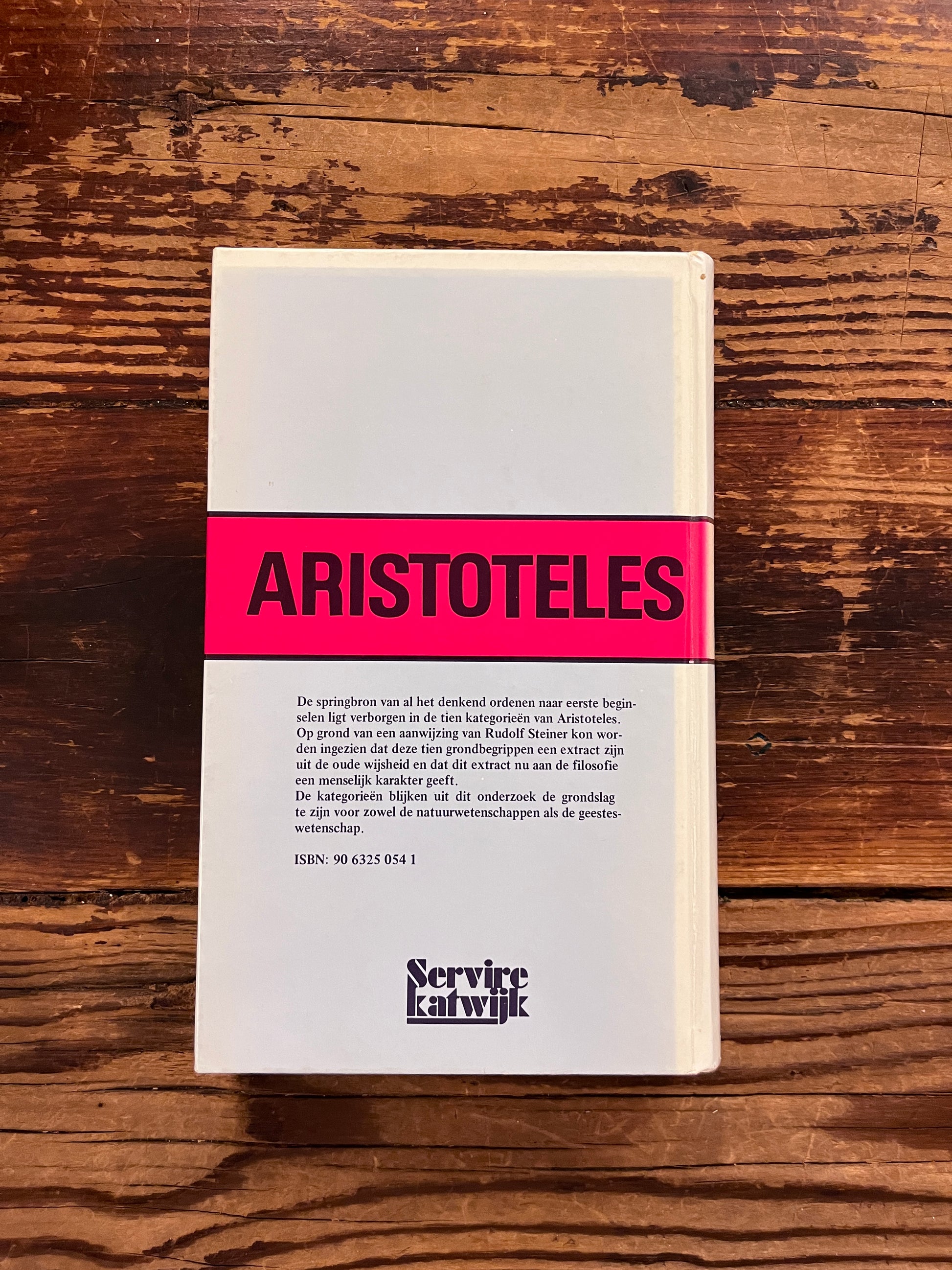 foto van de omslag van het boek " Aristoteles nieuw onderziek naar de betekenis van zijn categorieen" op houten achtergrond