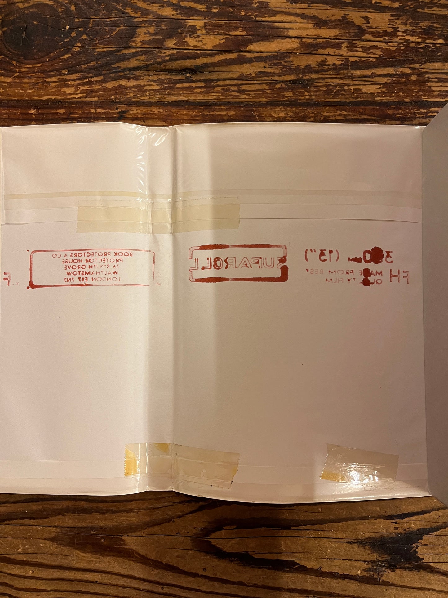 Inside of hte dust jacket of the book titled 'Merlin Dreams' by Peter Dickinson and illustrated by Alan Lee on a wooden surface 