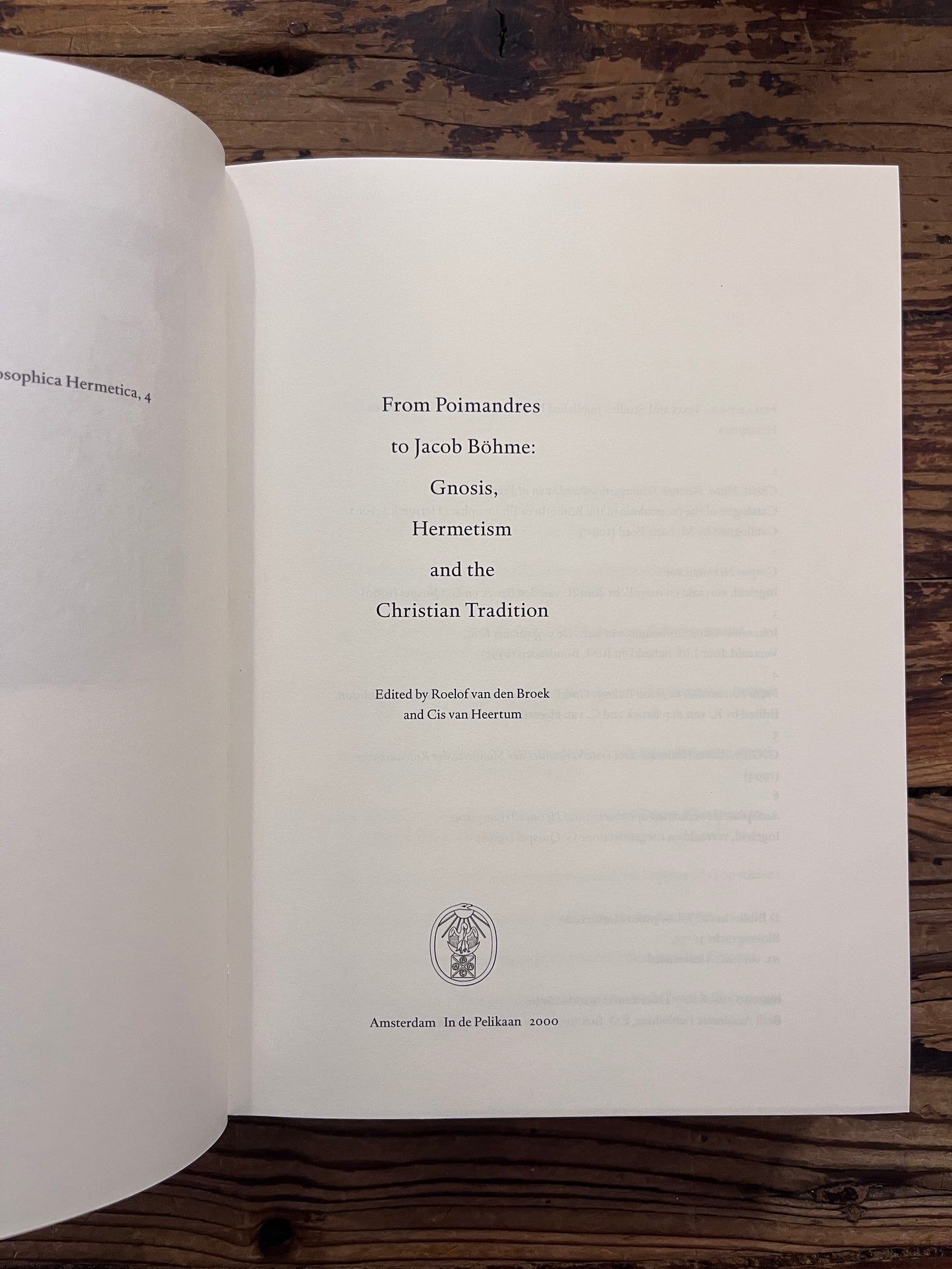 Open book titled 'From Poimandres to Jacob Böhme: Gnosis, Hermetism, and the Christian tradition Edited by Roelof van den Broek and Cis van Heertum' On a wooden surface