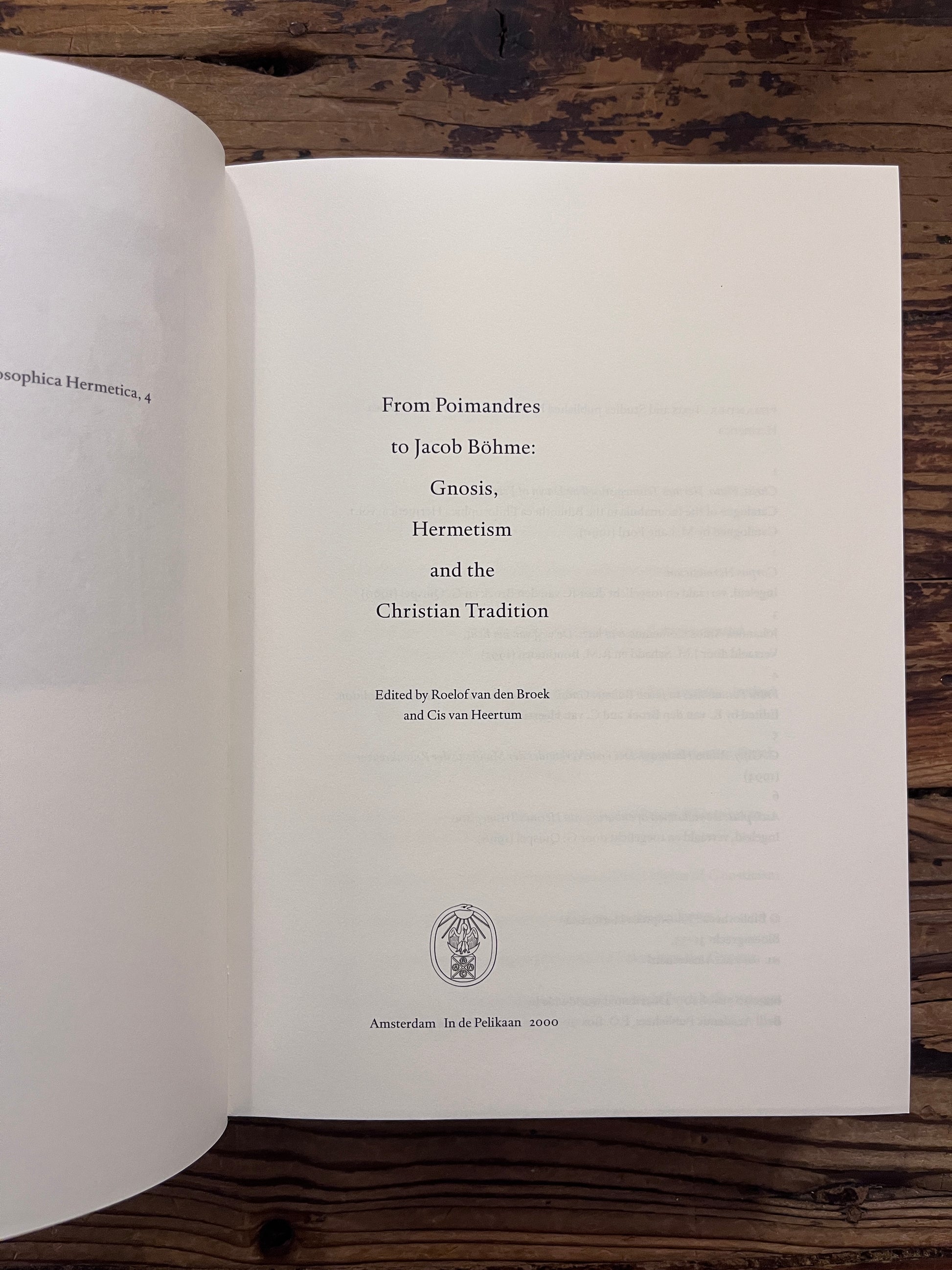 Open book titled 'From Poimandres to Jacob Böhme: Gnosis, Hermetism, and the Christian tradition Edited by Roelof van den Broek and Cis van Heertum' On a wooden surface