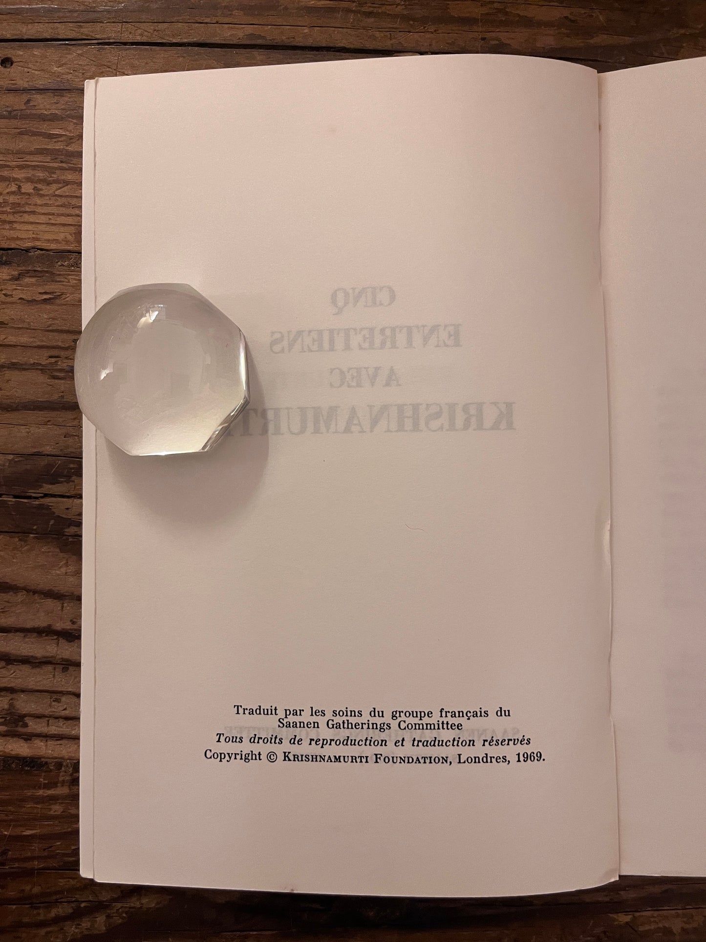 page d' edtiions du livre" cinq entretiens avec krishnamurti"  sur fond de bois