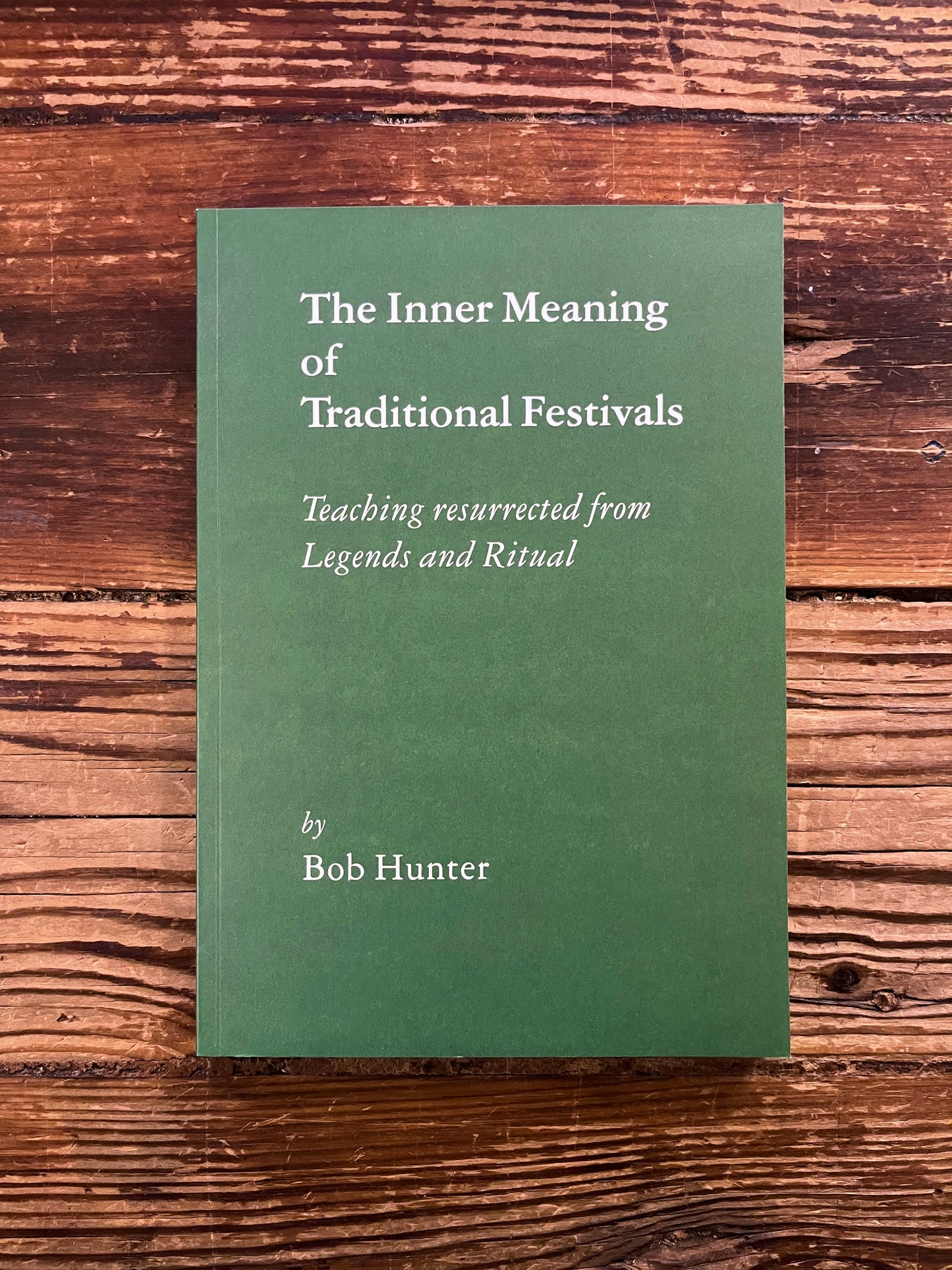 Book titled 'The Inner Meaning of Traditional Festivals' by Bob Hunter on a wooden surface