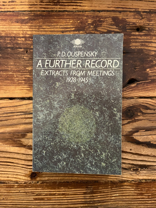 Cover of book titled 'a further record' by P.D. Ouspensky on a wooden surface 