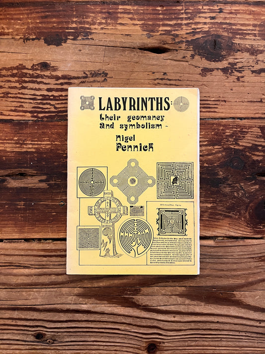 Front cover of booklet with the title 'Labyrinths, their geomancy and symbolism' by Nigel Pennick on a wooden surface 