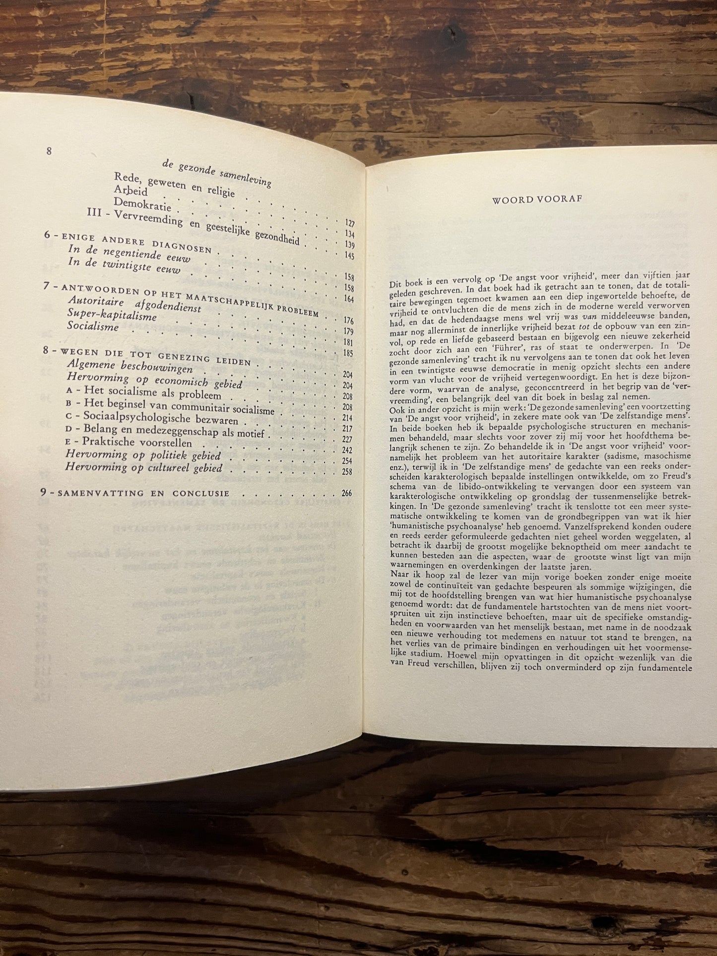 Open boek met de titel 'De gezonde samenleving' door Erich Fromm op een houten achtergrond 