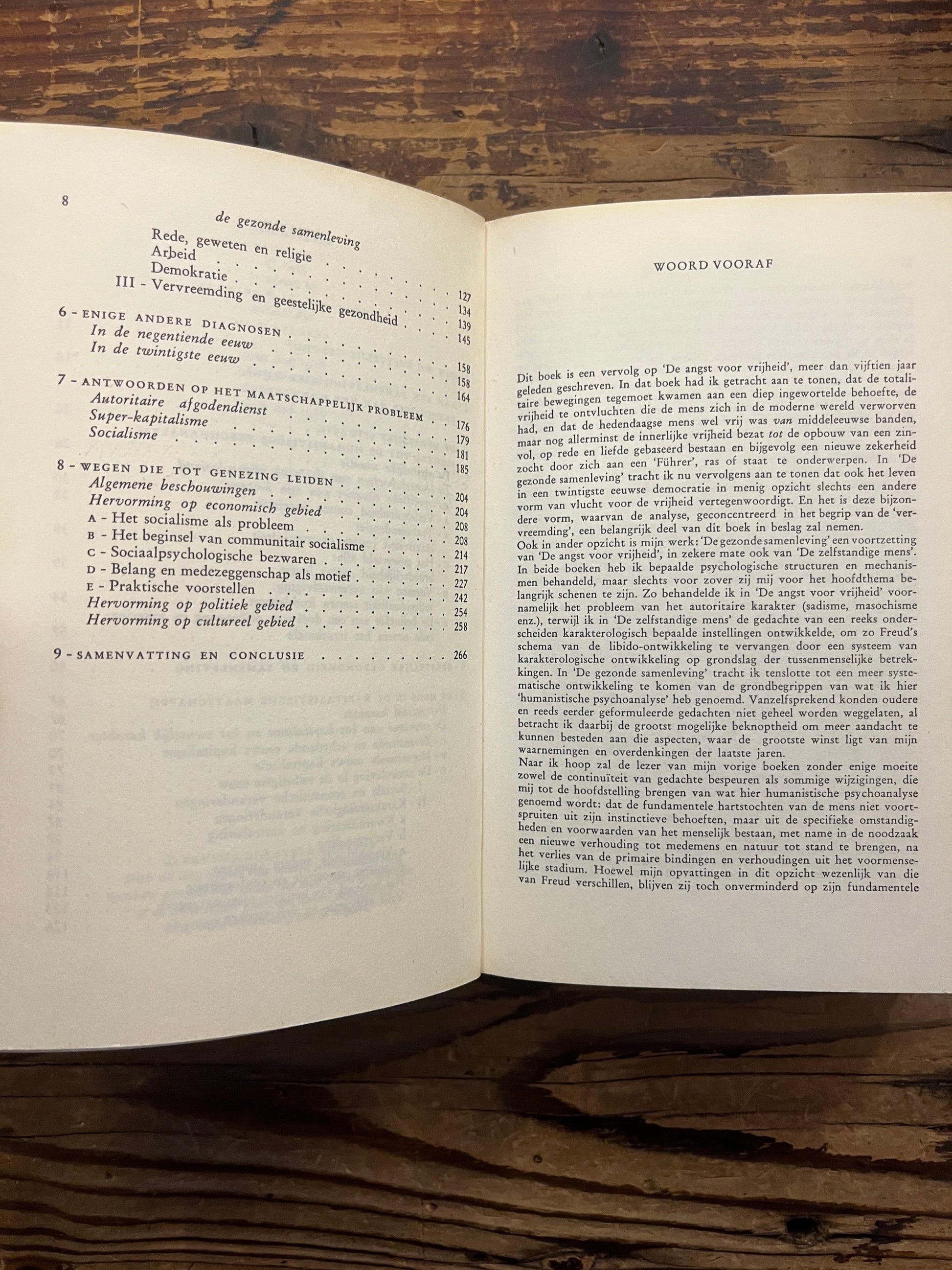 Open boek met de titel 'De gezonde samenleving' door Erich Fromm op een houten achtergrond 