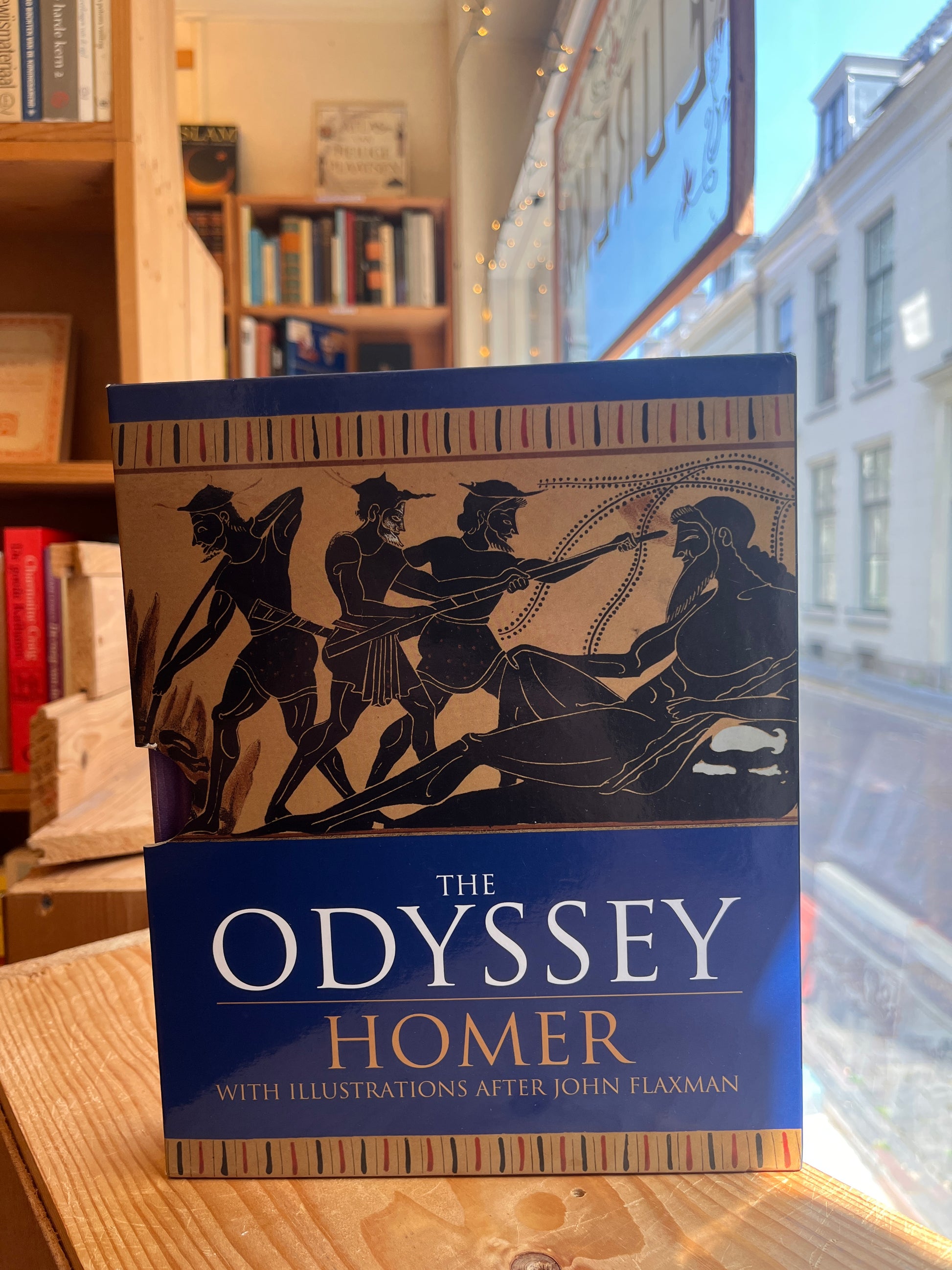 front cover of book titled 'The Odyssey' by Homer and translated by A. Pope, in fornt of a window