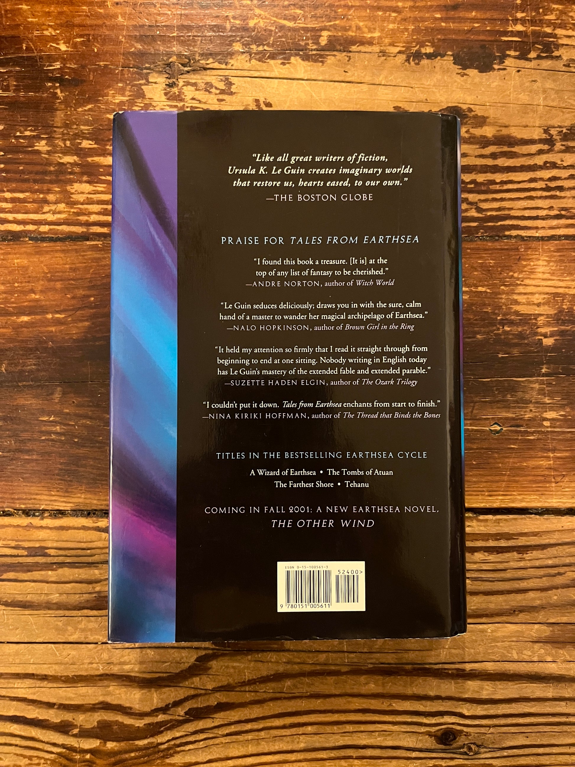 Back cover of book titled 'Tales from Earthsea' by Ursula K. Le Guin on a wooden surface