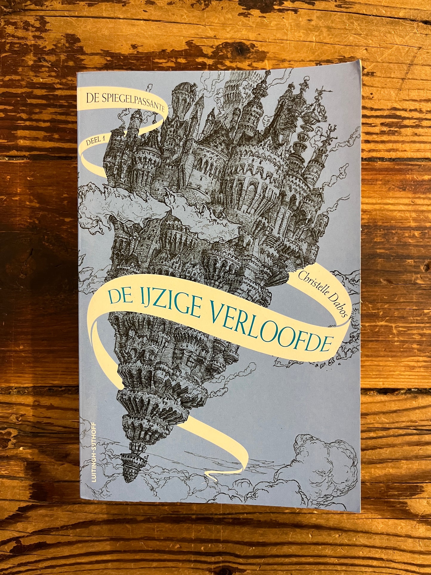 Voorkant van boek met de titel 'de ijzige verloofde' door Christelle Dabos op een houten achtergrond 