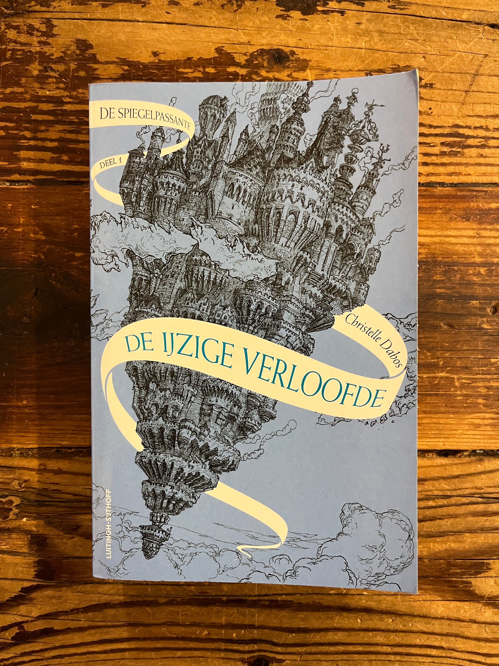Voorkant van boek met de titel 'de ijzige verloofde' door Christelle Dabos op een houten achtergrond 