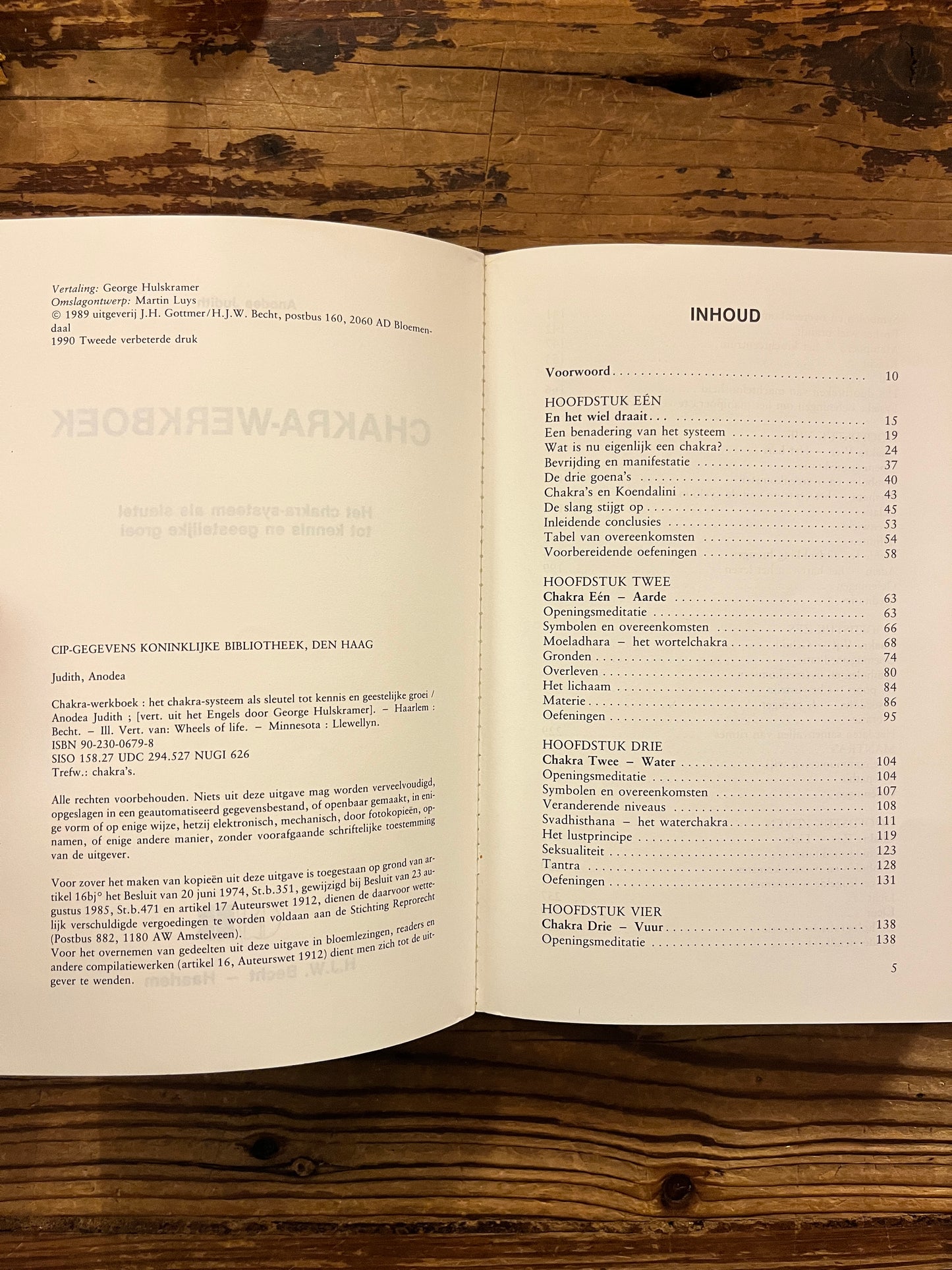 Open boek met de titel 'Chakra werkboek' door Andrea Judith op een houten achtergrond 