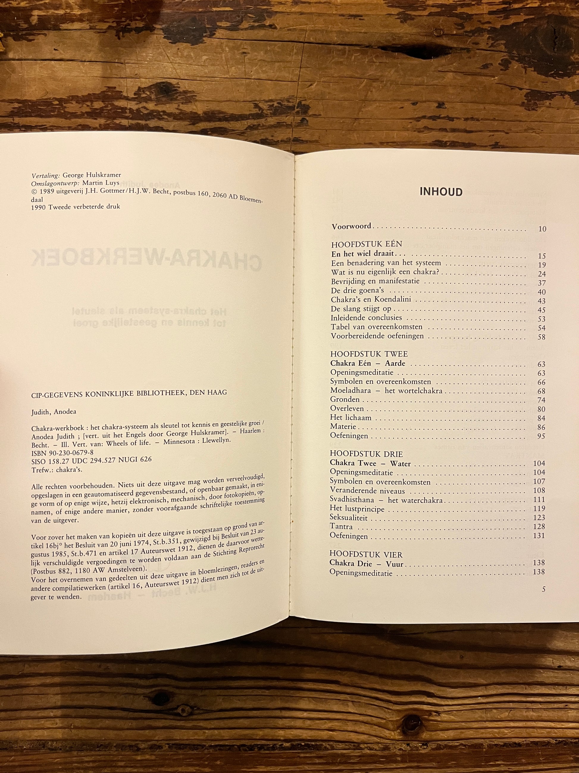 Open boek met de titel 'Chakra werkboek' door Andrea Judith op een houten achtergrond 