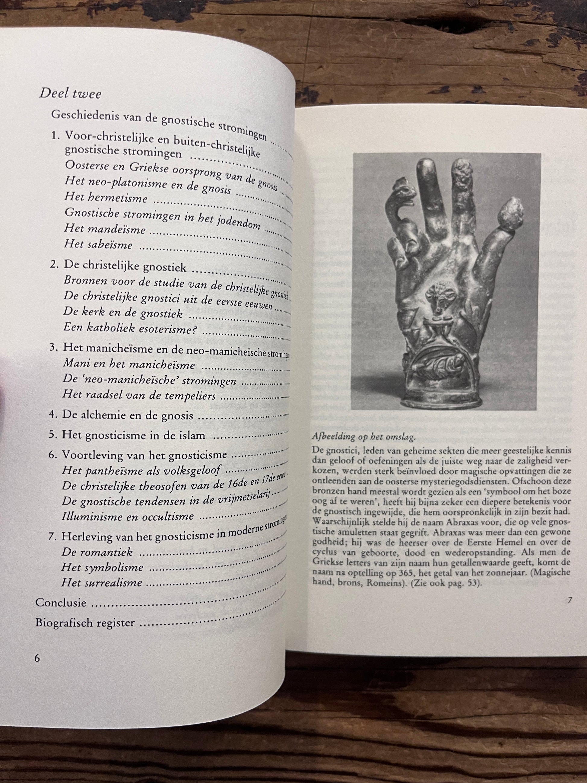 Open boek met de titel 'De Gnosis' door Serge Hutin op een houten achtergrond 