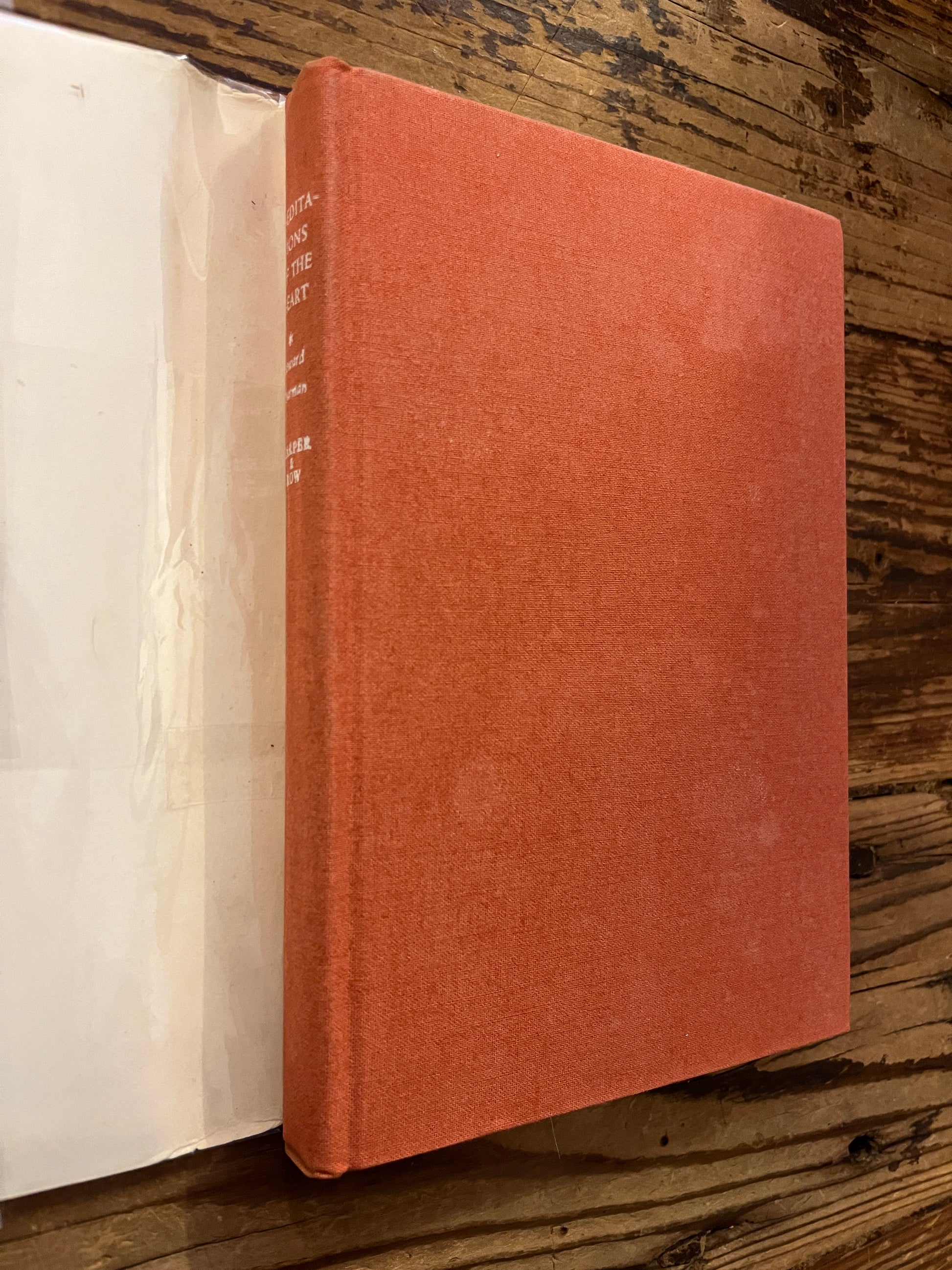 Book titled 'Meditations of the Heart' by Howard Thurman on a wooden surface
