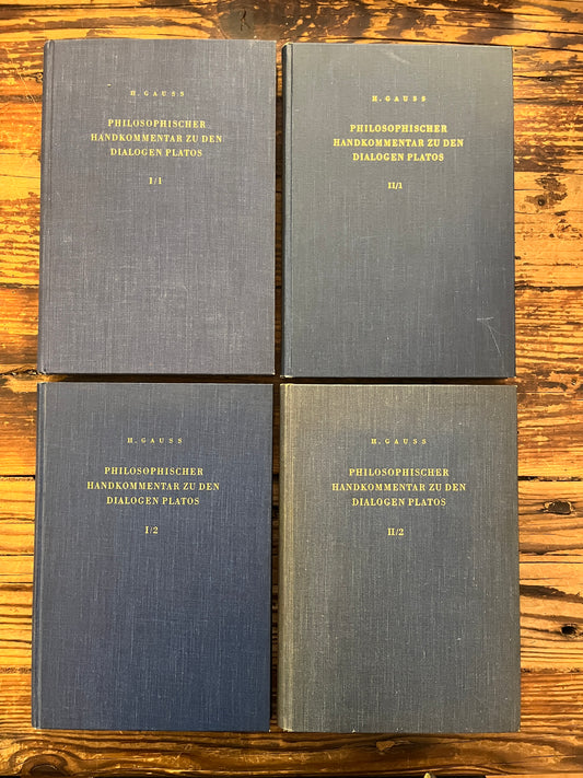 four books titled 'Philosophischer Handkommentar zu den Dialogen Platos' by H. Gauss on a wooden surface 