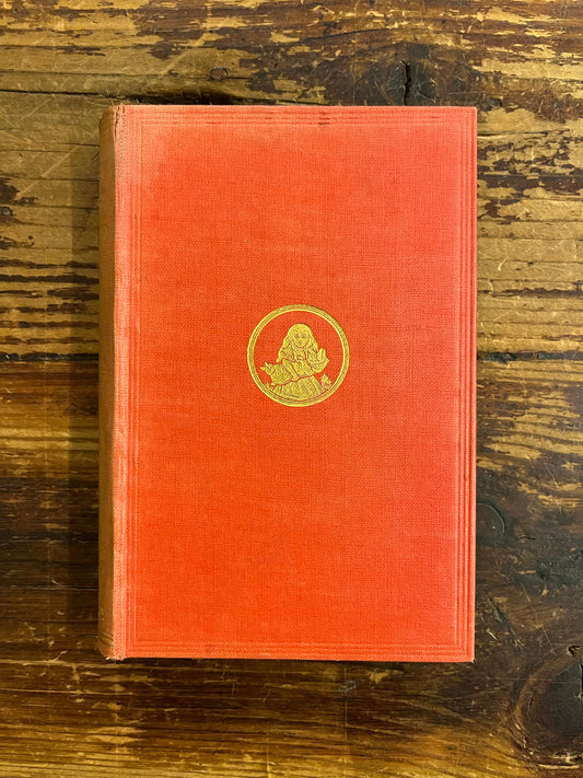 front cover of a 1922 macmillan & co miniature edition of 'Alice's adventures in wonderland' by Lewis Carroll on a wooden surface