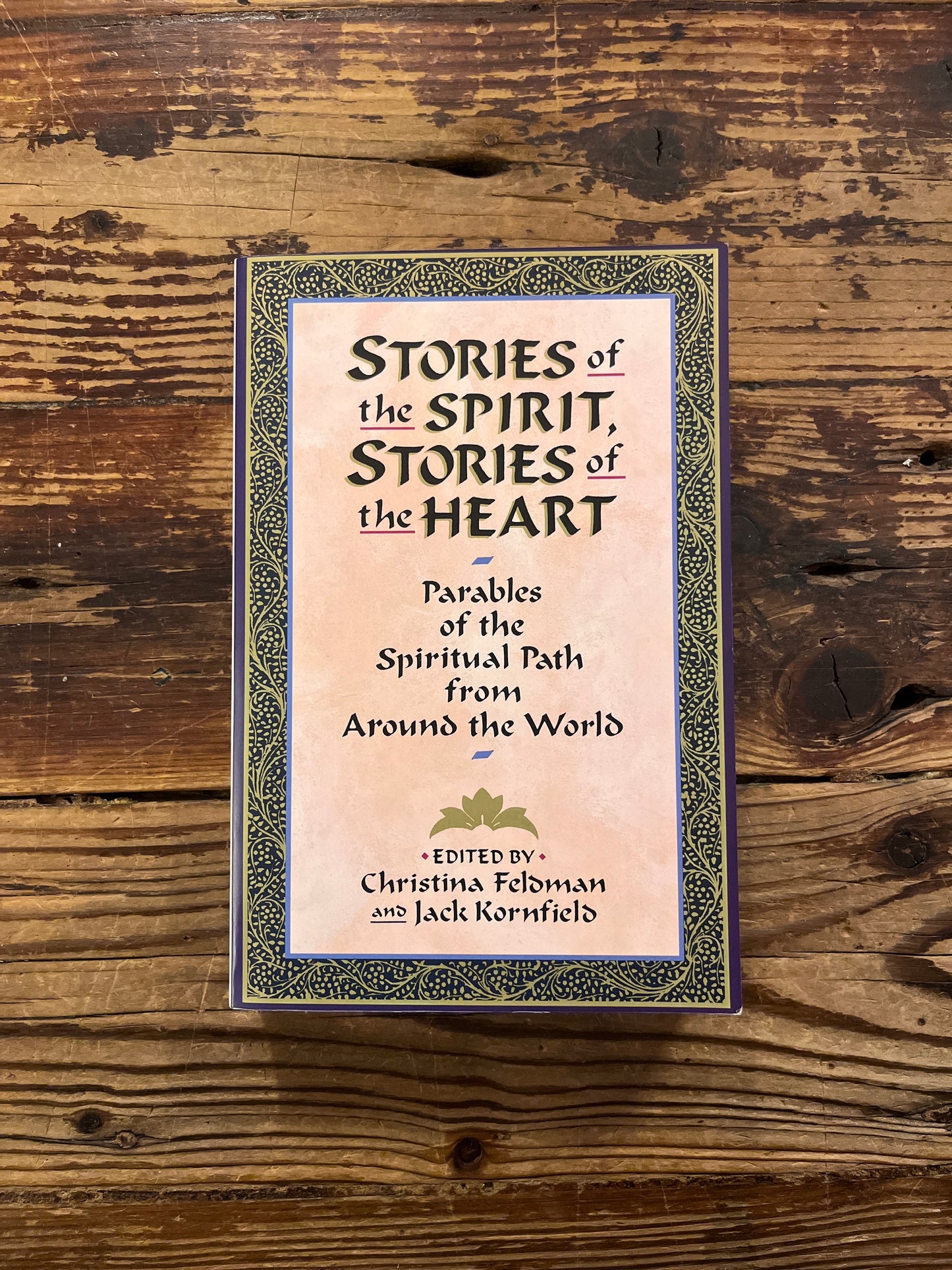 Book titled 'Stories of the Spirit, Stories of the Heart' on a wooden surface