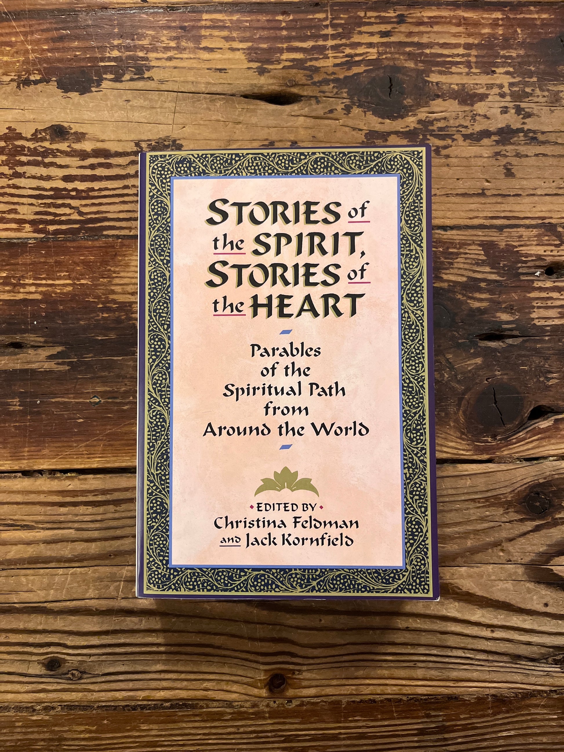 Book titled 'Stories of the Spirit, Stories of the Heart' on a wooden surface
