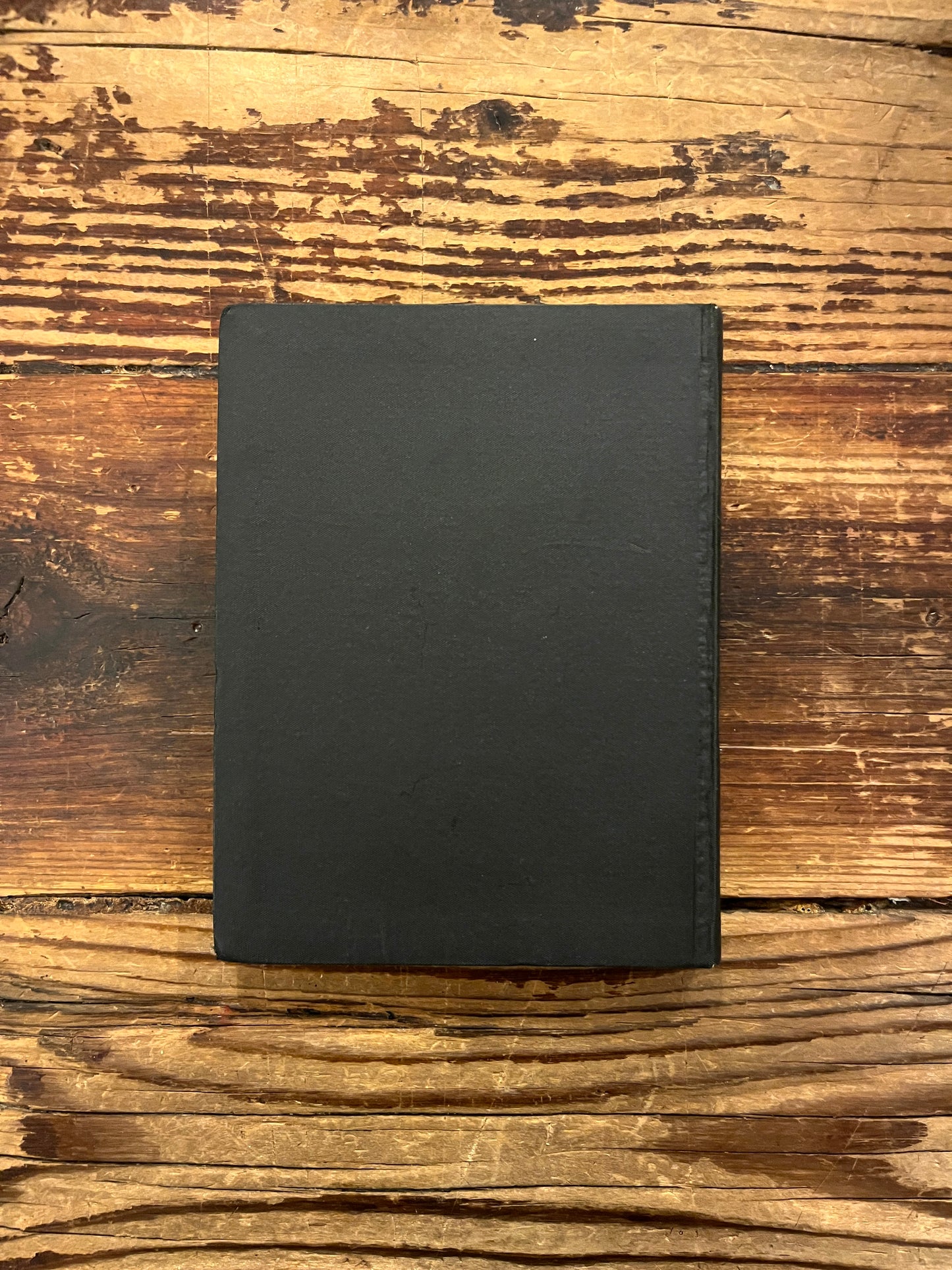 Back cover of book titled 'The divine symphony or Vadan'  by Hazrat Inayat Khan on a wooden surface 