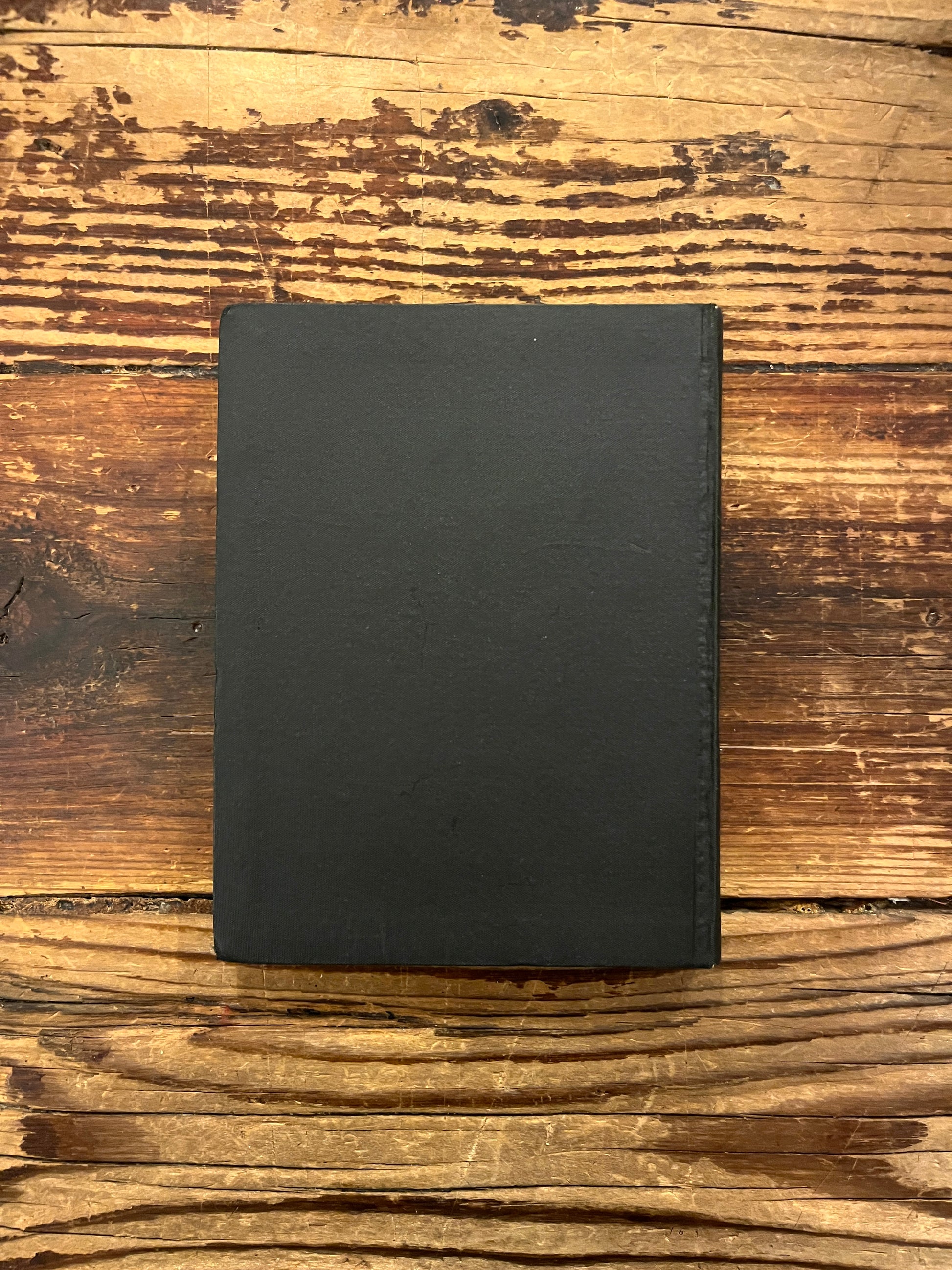 Back cover of book titled 'The divine symphony or Vadan'  by Hazrat Inayat Khan on a wooden surface 