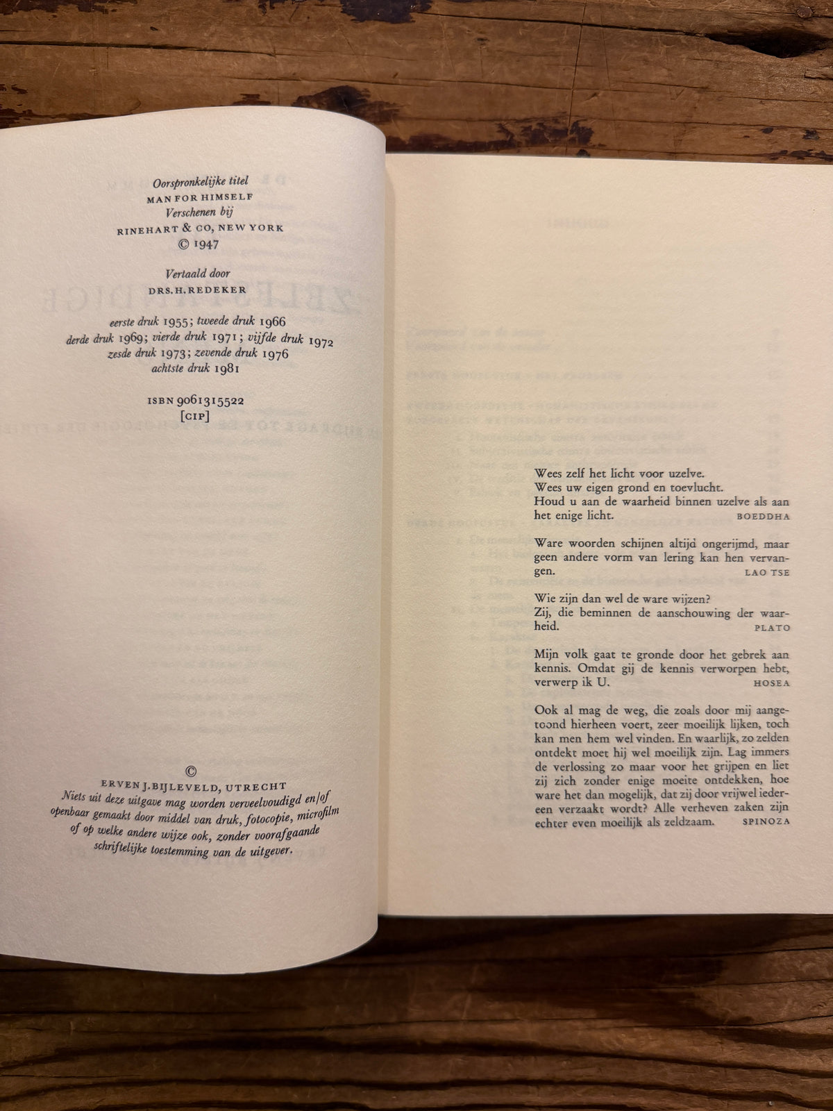 Open boek met de titel 'De zelfstandige mens' door Erich Fromm op een houten achtergrond 