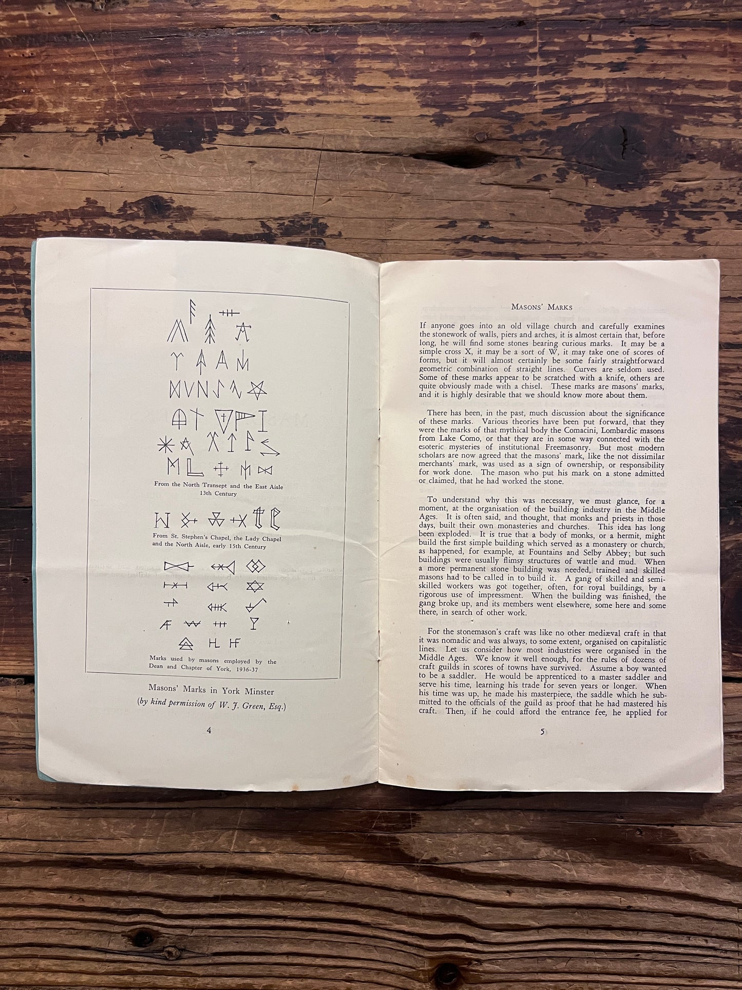 Open book titled 'Masons' Marks' by F.W. Brooks on a wooden surface