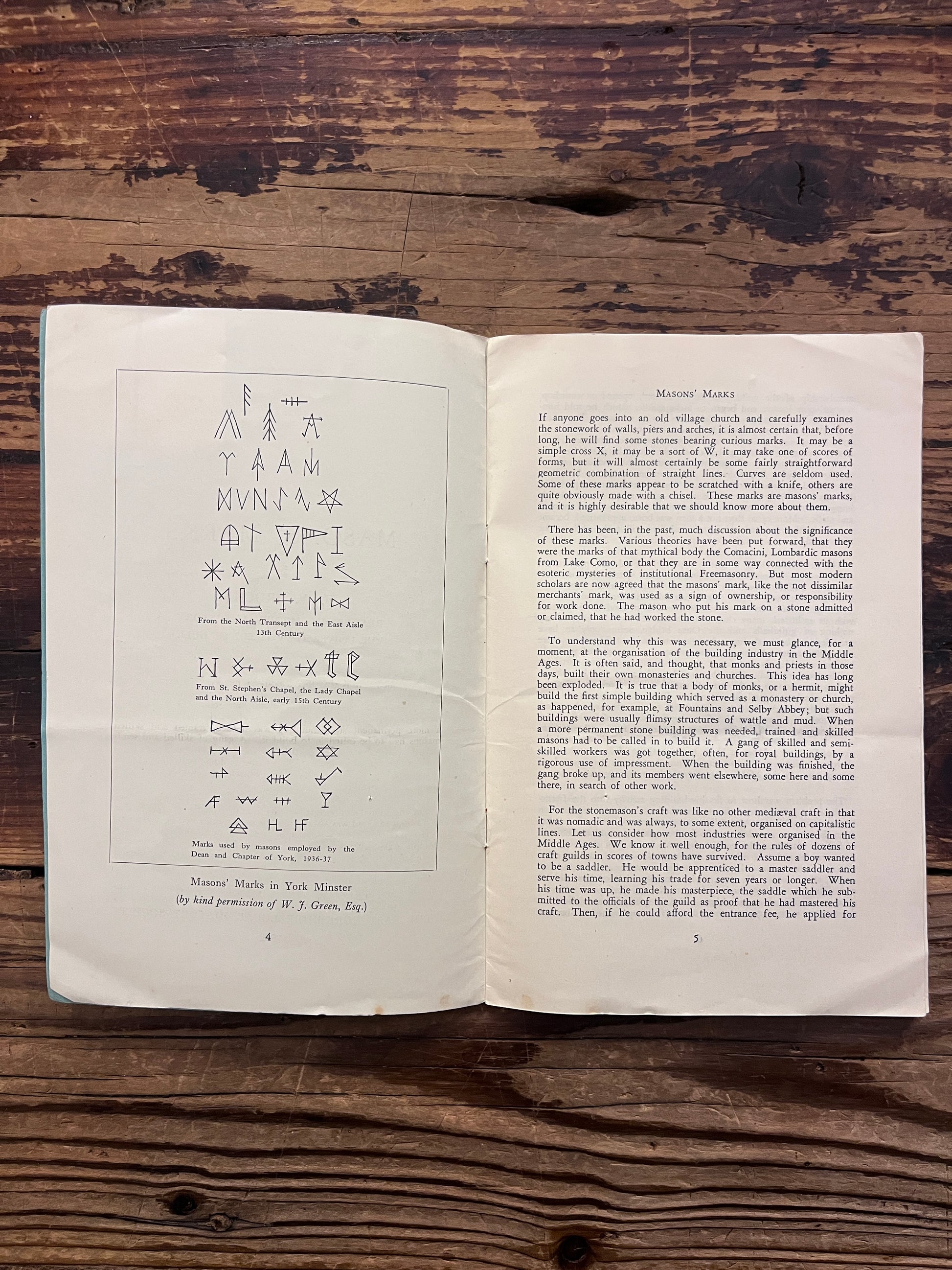 Open book titled 'Masons' Marks' by F.W. Brooks on a wooden surface