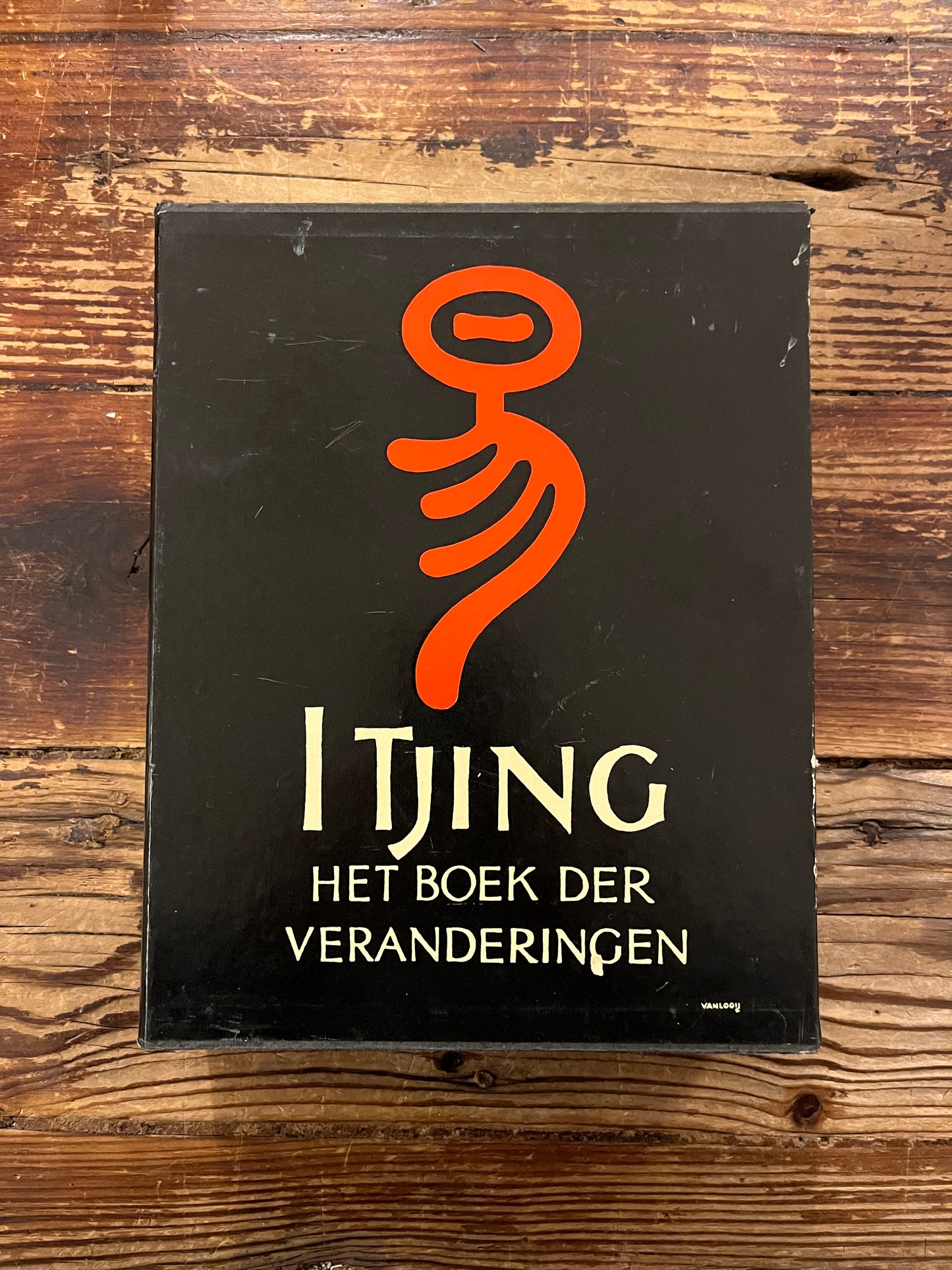 Casette met twee boeken met de titel 'I Tjing: Het Boek Der Veranderingen' op een houten achtergrond